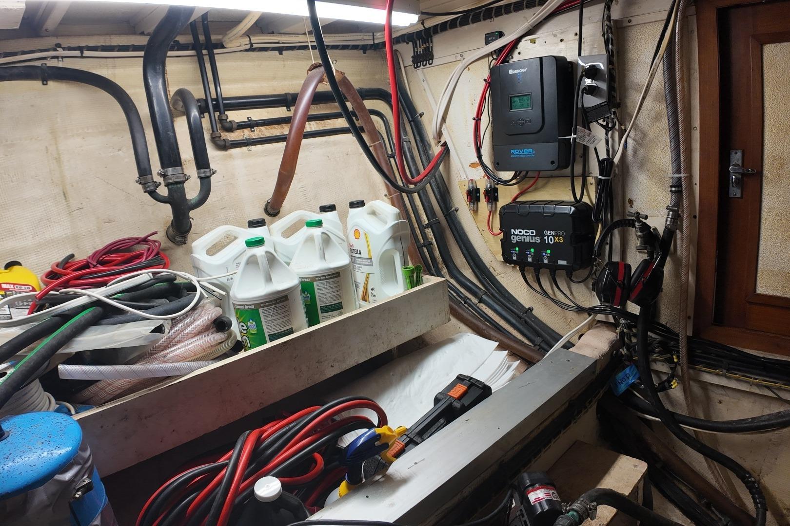 Engine room of a 1978 Grand Banks 42 Classic with cables, hoses, and equipment.