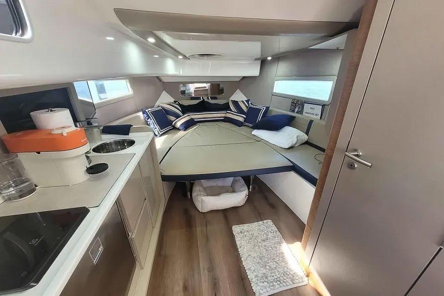 Luxurious interior of 2024 Hanover 387 yacht with modern kitchen and cozy seating area.