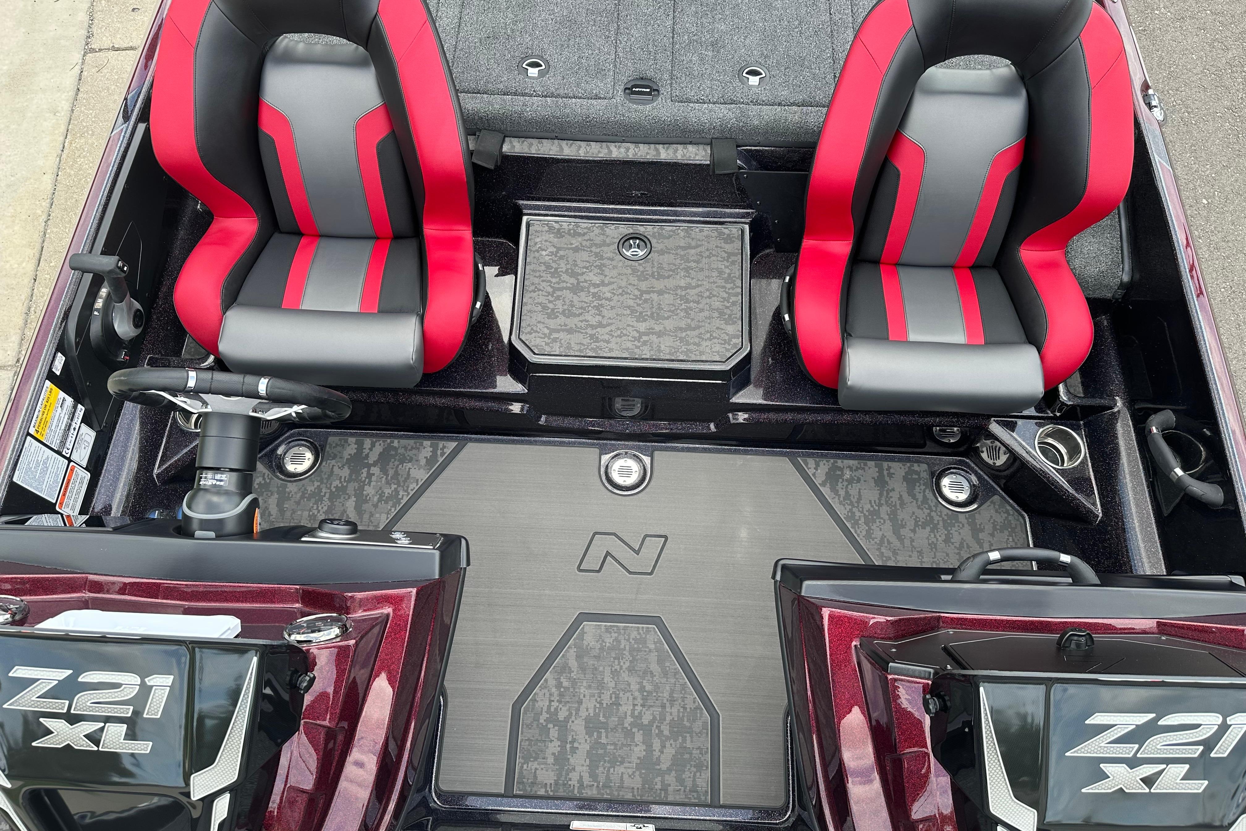 2026 Nitro Z21 XL boat interior with red and gray seats, steering wheel, and storage compartments.