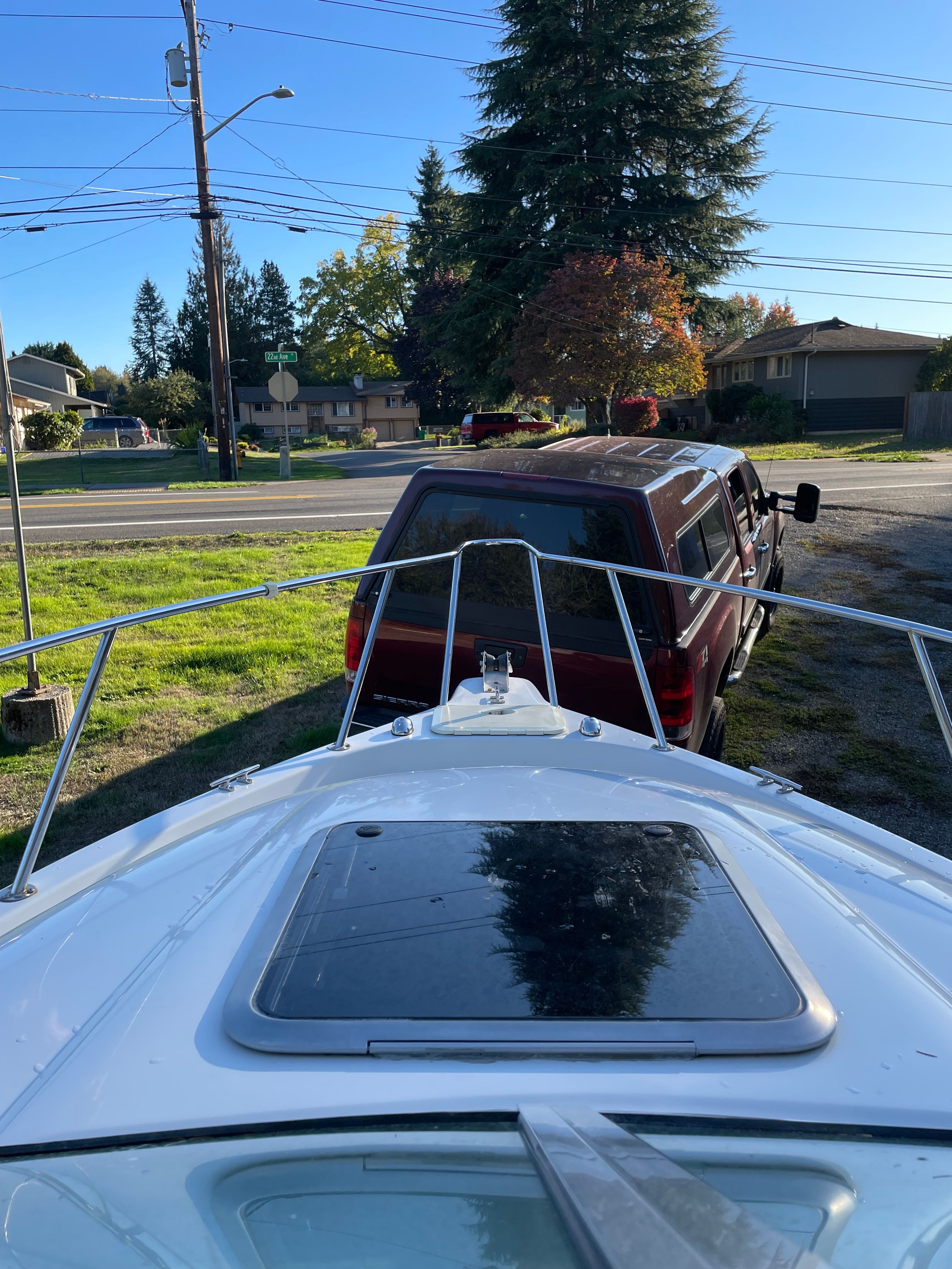 A 2001 Bluewater 2100 Sport Fisher on a trailer in front of a red vehicle.