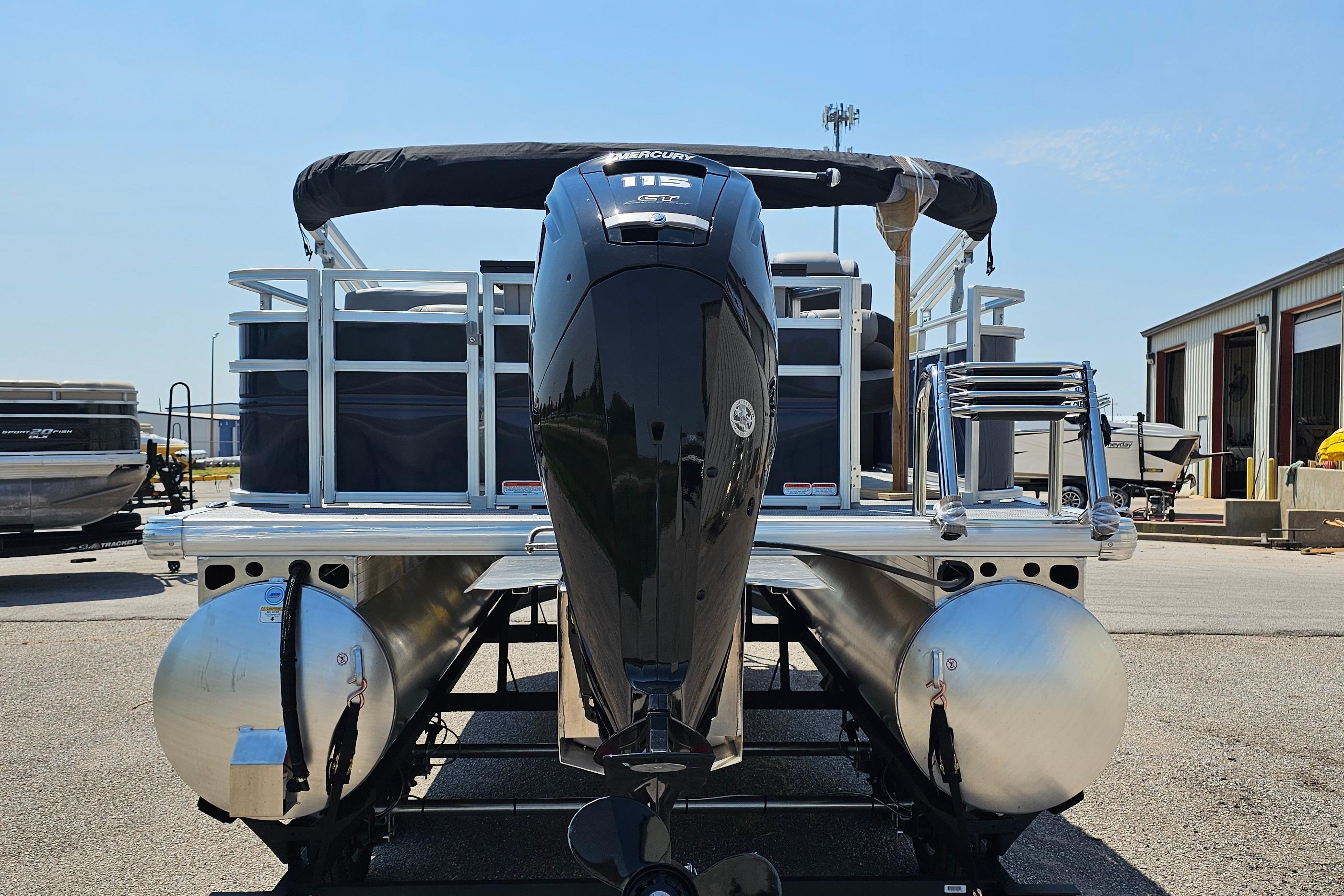 2026 Sun Tracker SportFish 20 DLX pontoon boat with powerful outboard motor, docked outdoors.