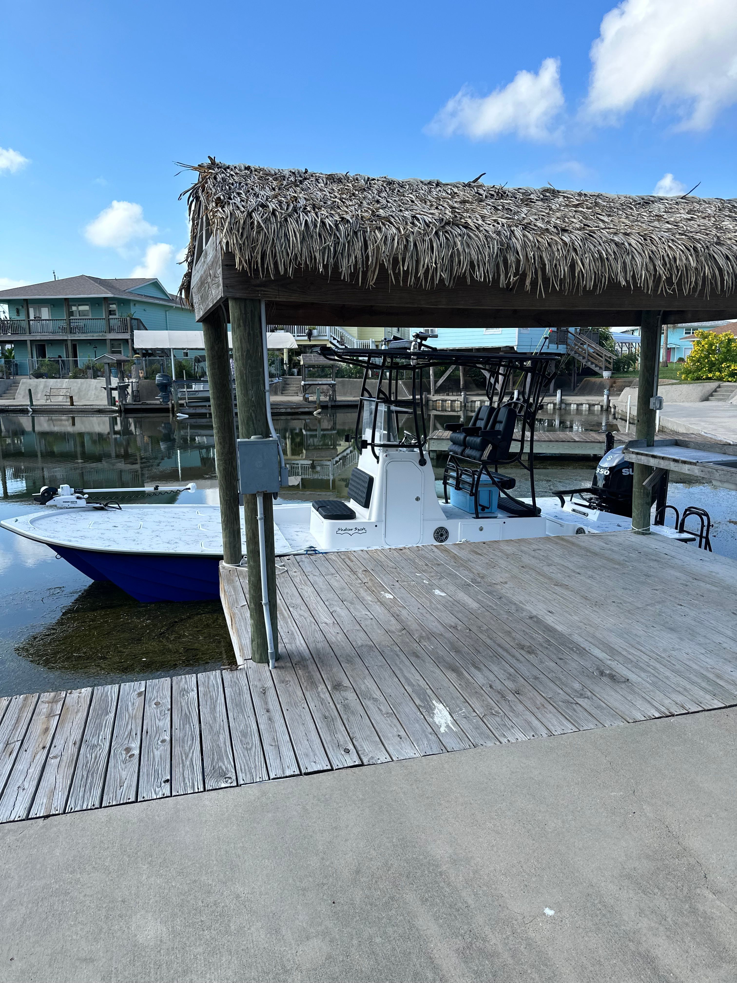 Shallow Sport 25 X3 boat at dock under thatched roof, 2023 model.