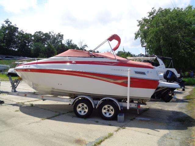 2006 Crownline 220 CCR boat on trailer, red and white design, parked outdoors.