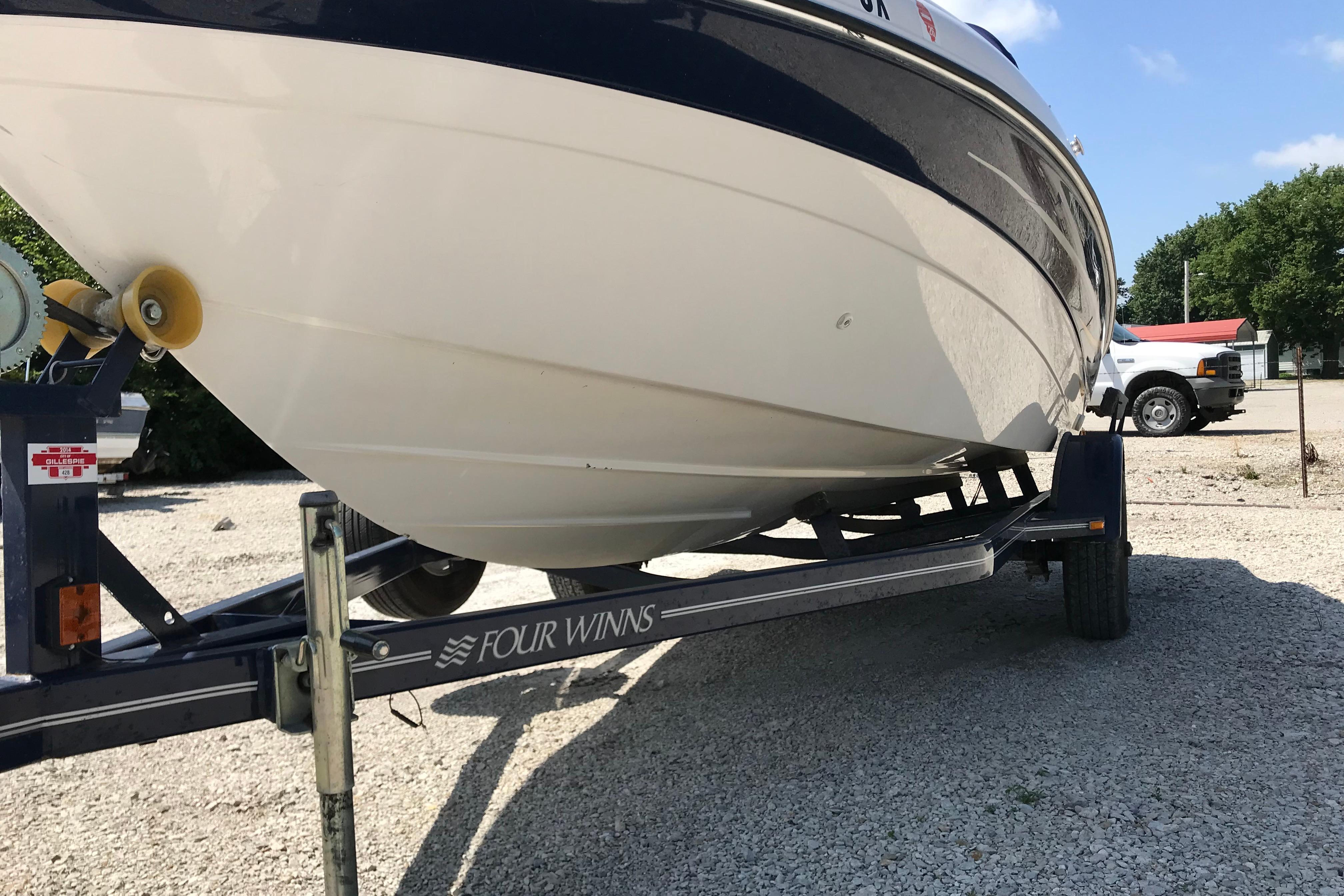 2005 Four Winns 180 Horizon FS boat on trailer, parked outdoors.