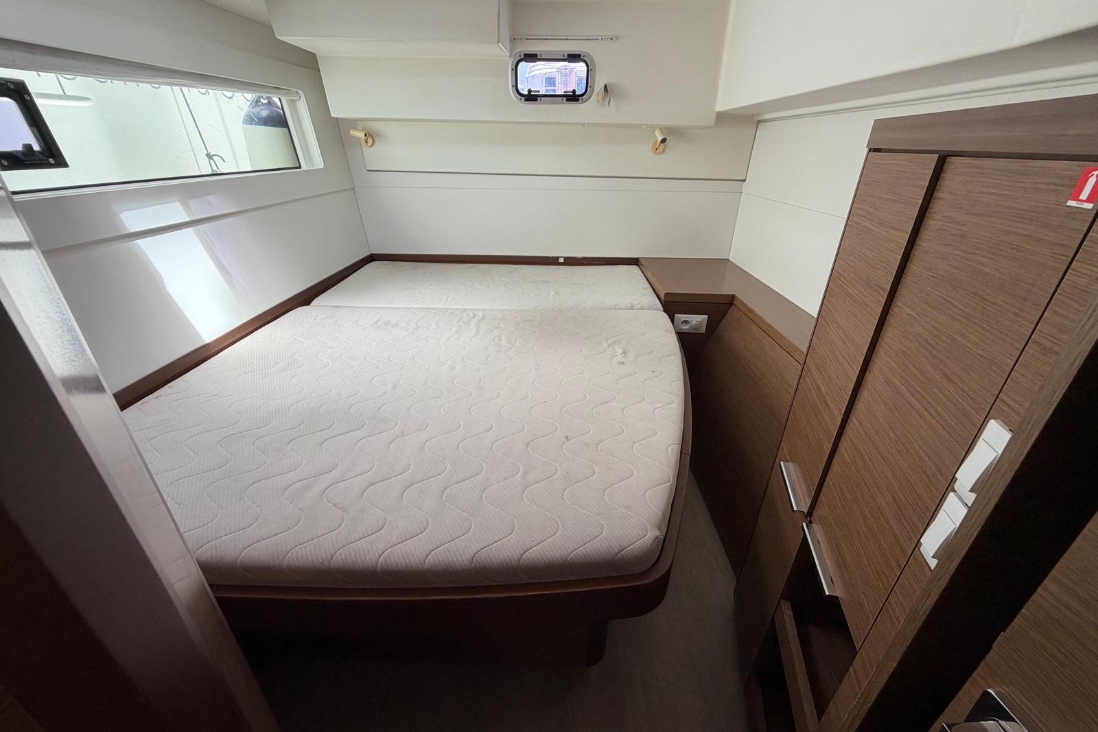 Luxurious cabin interior of 2020 Lagoon 40 yacht with comfortable bed and wooden furnishings.