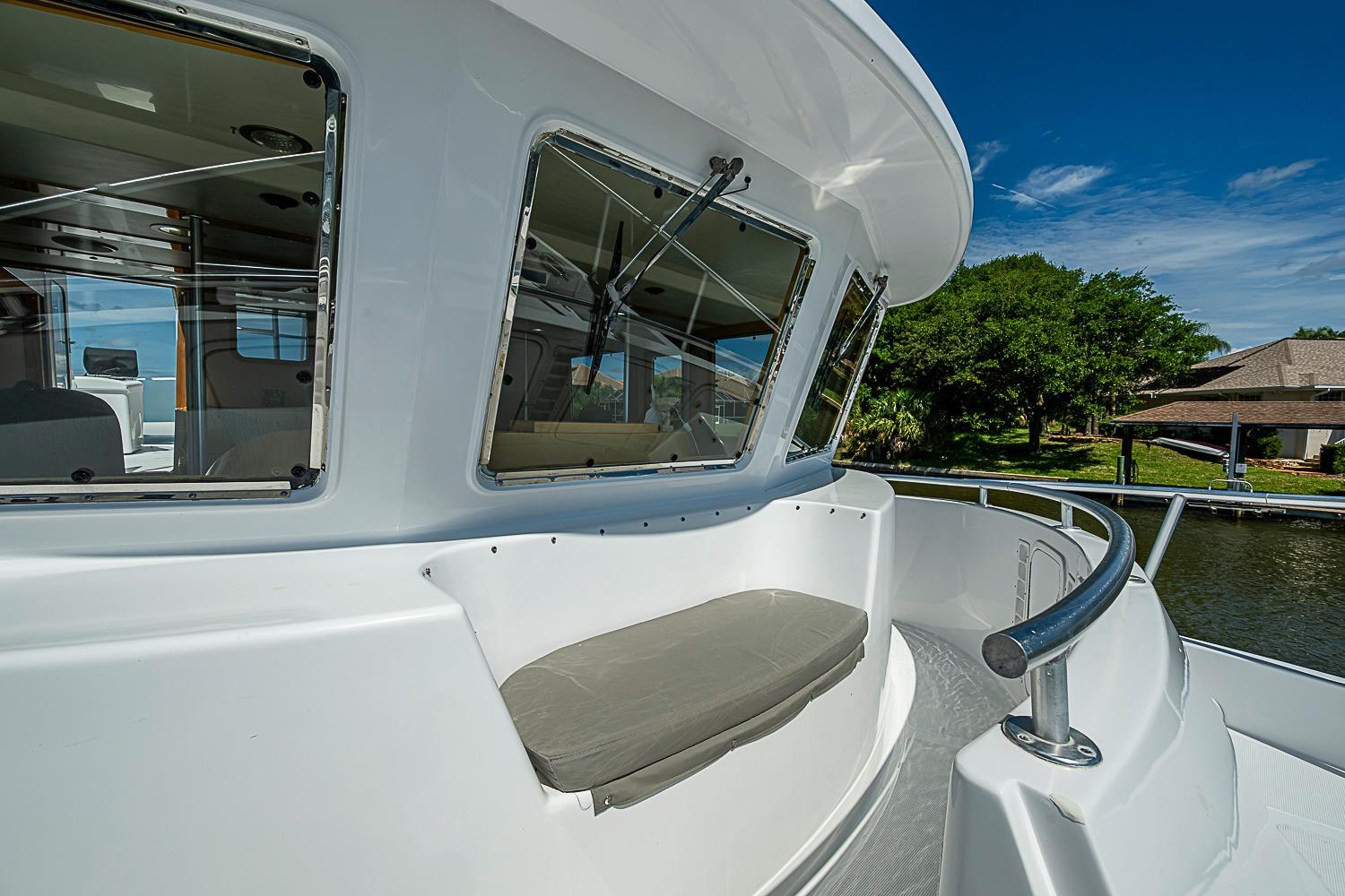 2003 Magna Marine Nova Scotia 47 boat deck with cushioned seating and scenic waterfront view.
