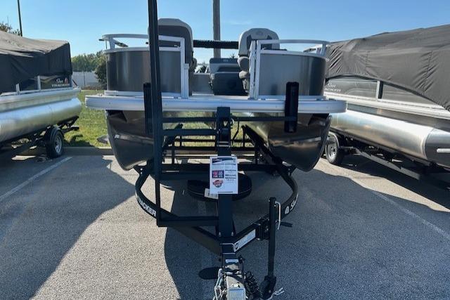 2026 Sun Tracker Bass Buggy 16 XL Select pontoon boat on trailer in parking lot.