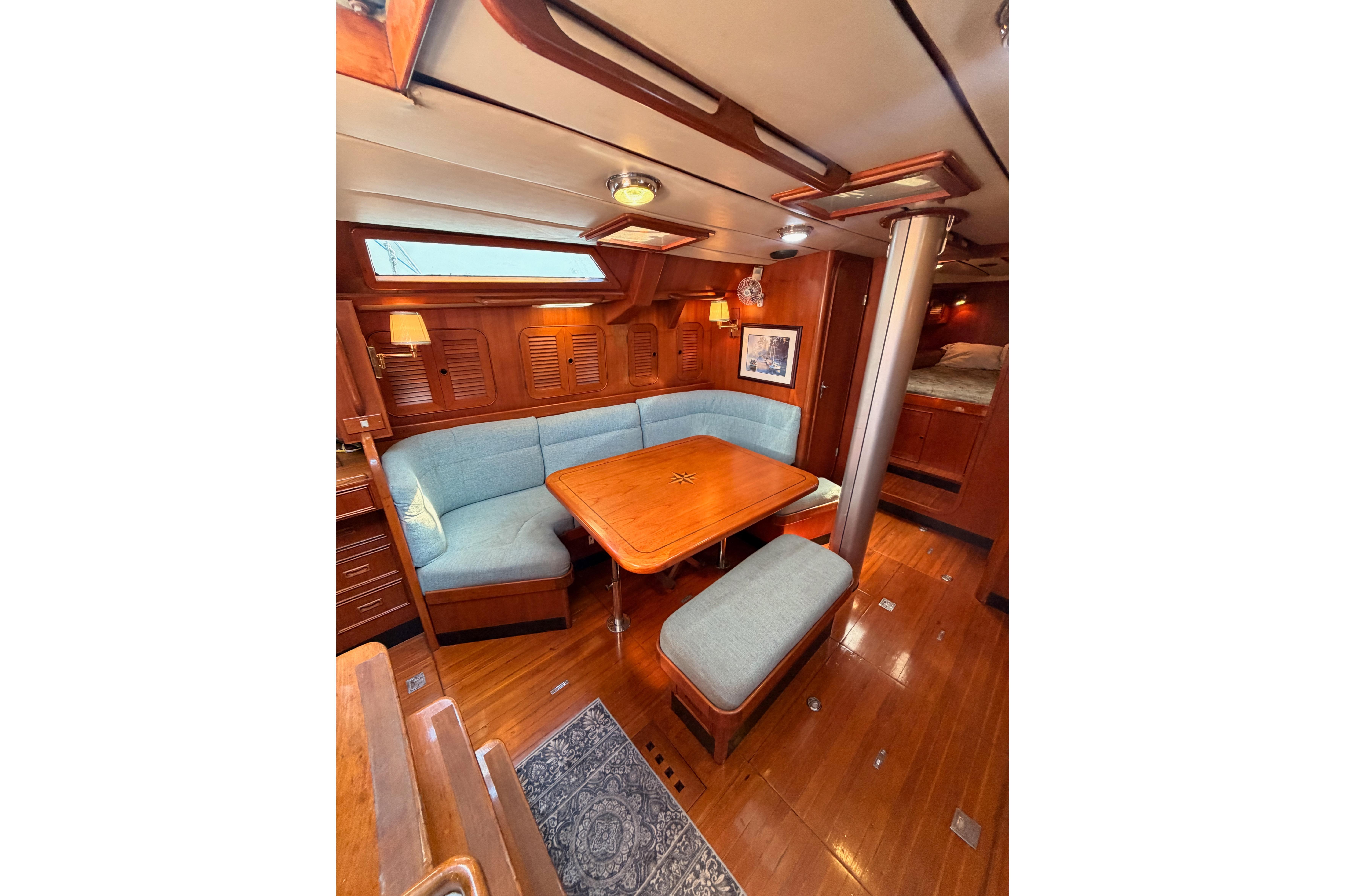 Luxurious interior of a 1991 Hylas 51 yacht with wooden finishes and cozy seating.
