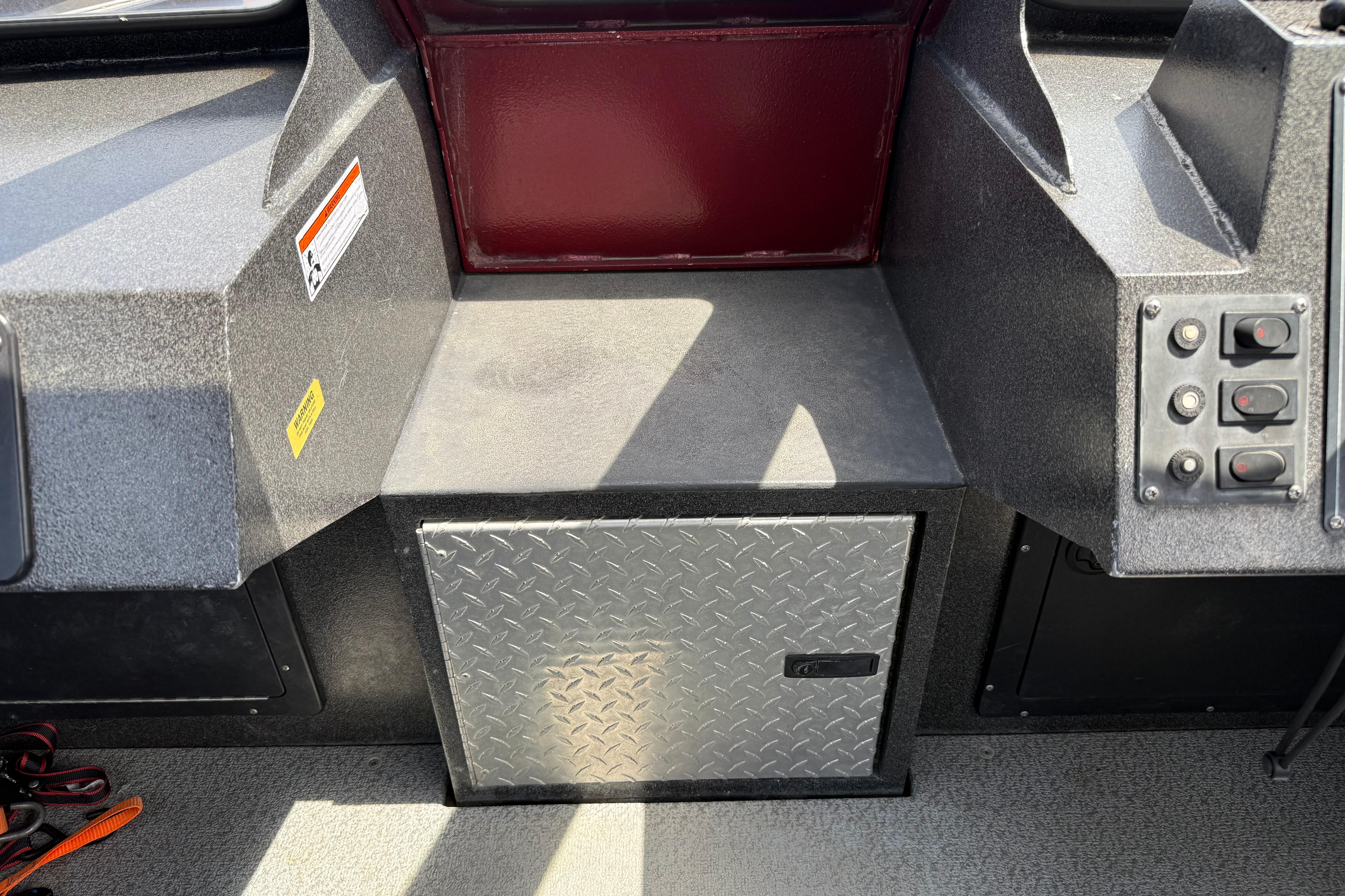 Interior of a 2005 Willie Raptor 21' boat with control panel and storage compartment.