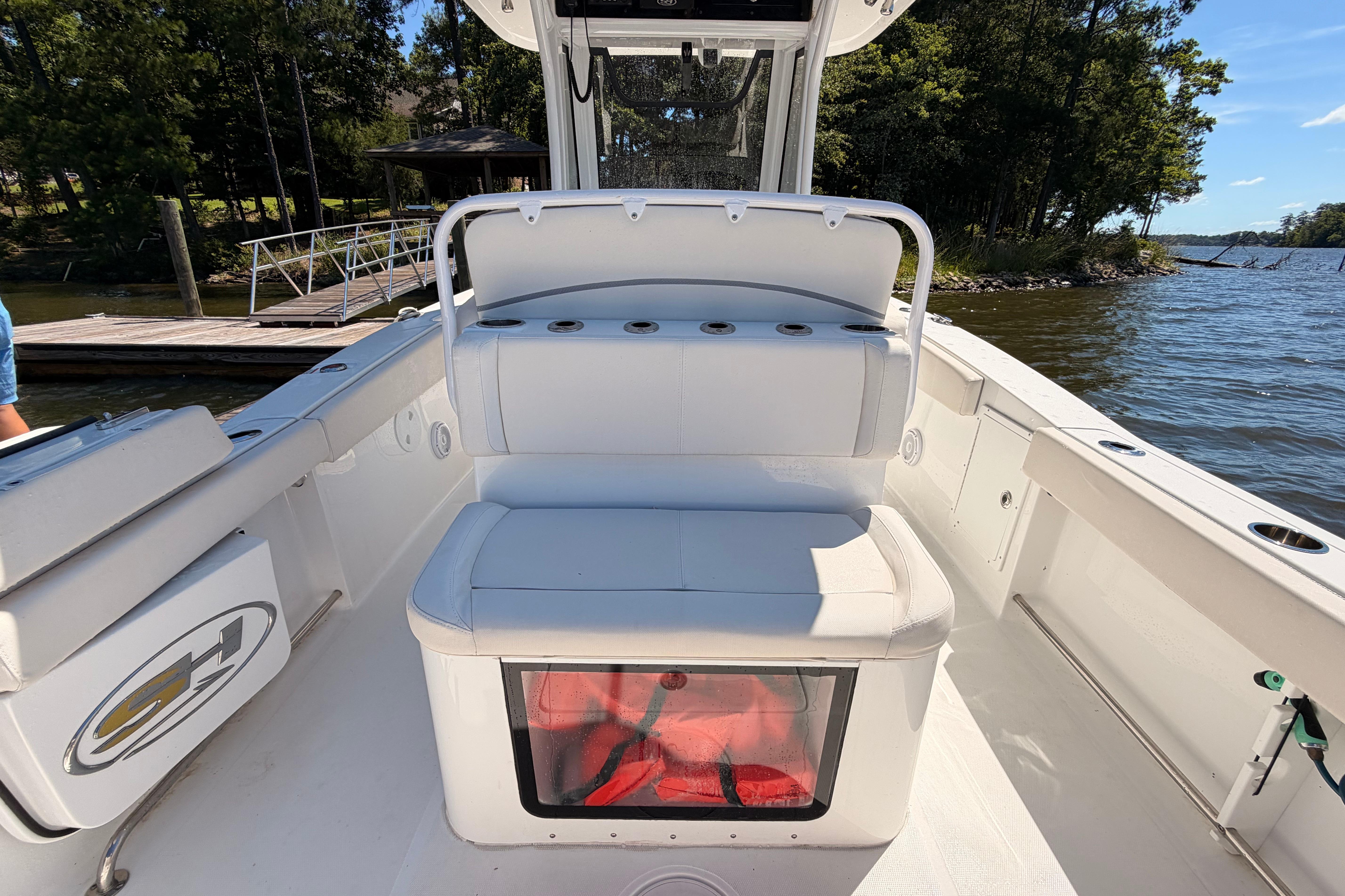 2024 Sea Hunt Gamefish 27 Coffin Box boat interior with seating and storage, dockside view.
