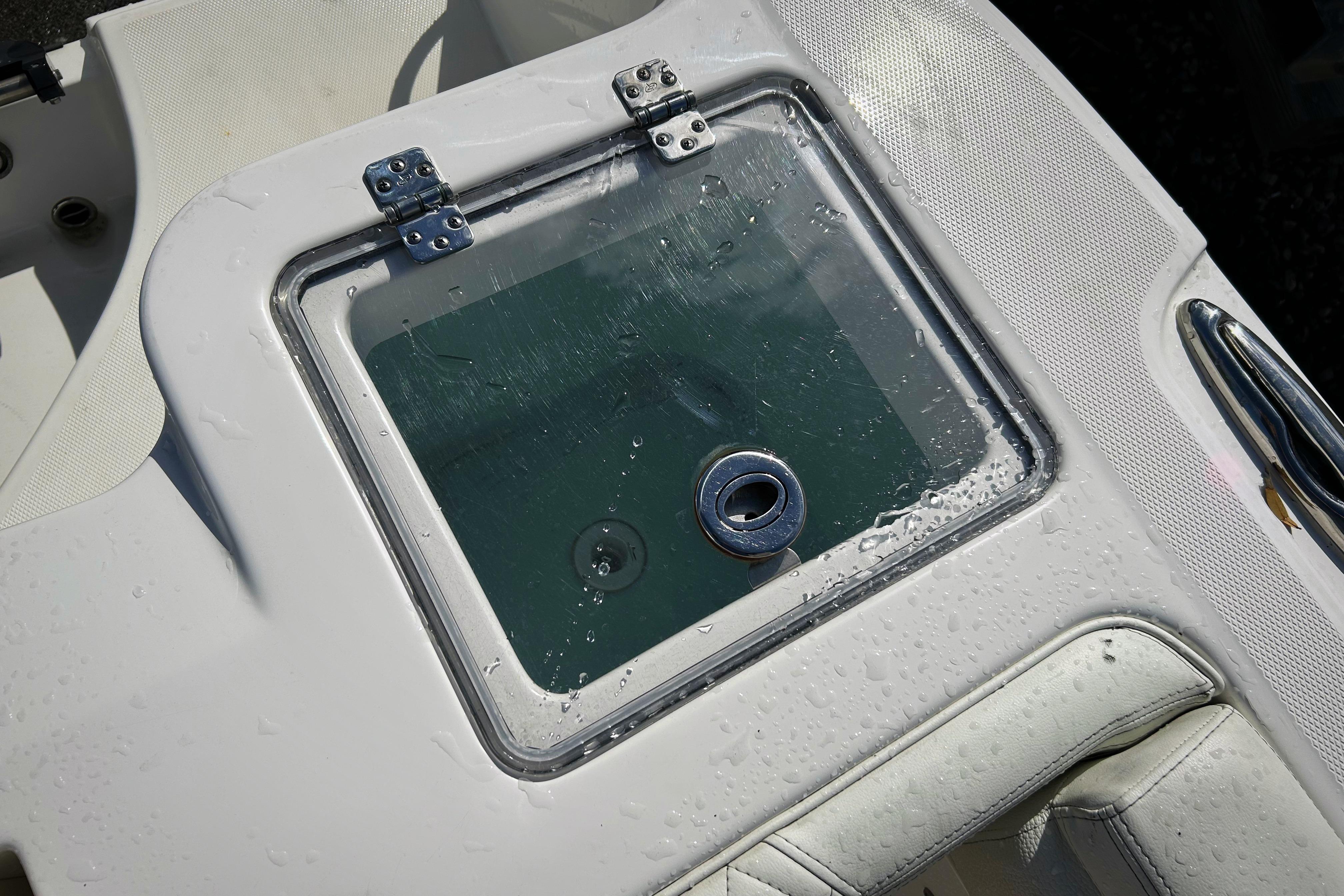 Livewell on 2023 Edgewater 262CX Crossover boat, featuring a transparent lid and stainless steel hinges.