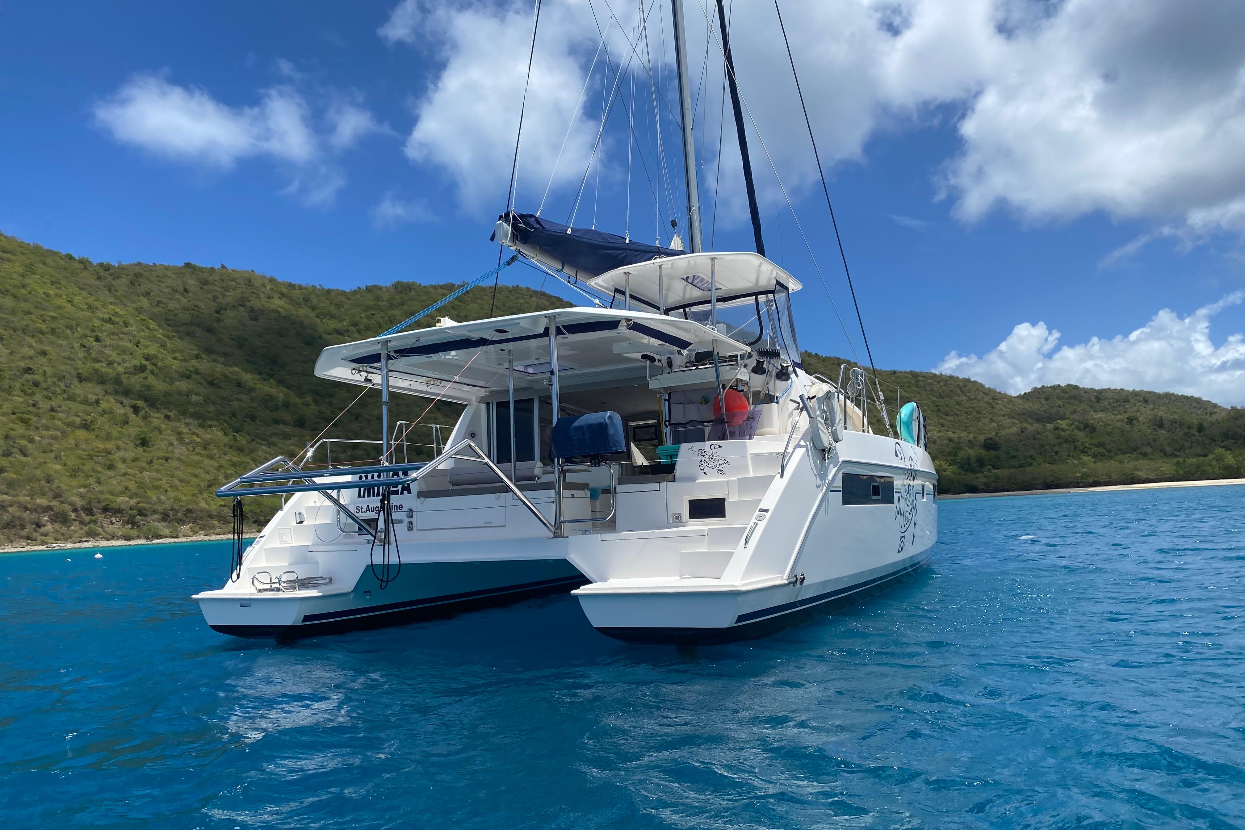 2017 Leopard 40 catamaran anchored in clear blue water near a lush green island.
