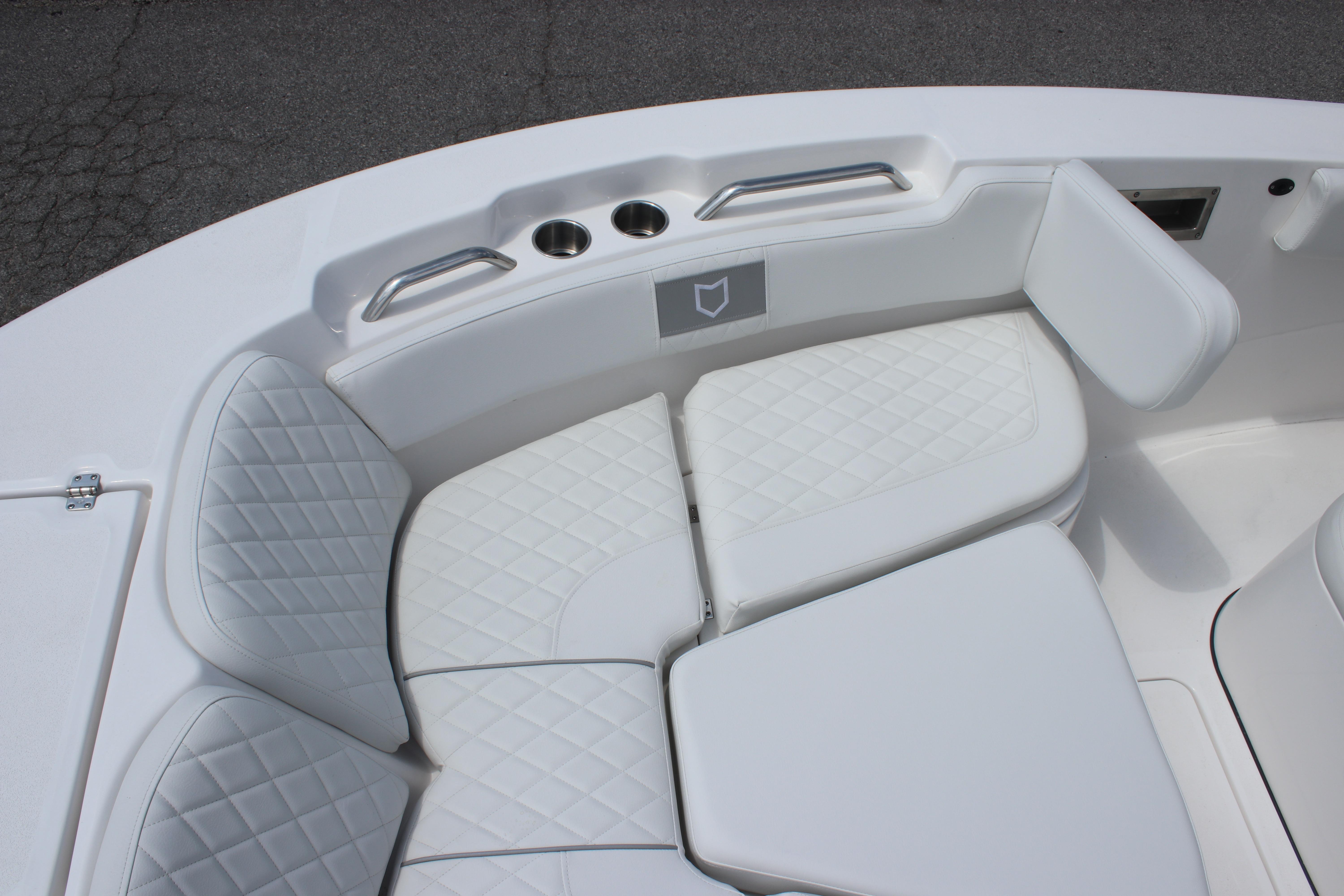 2026 Sea Fox 248 Commander boat interior with white cushioned seating and cup holders.