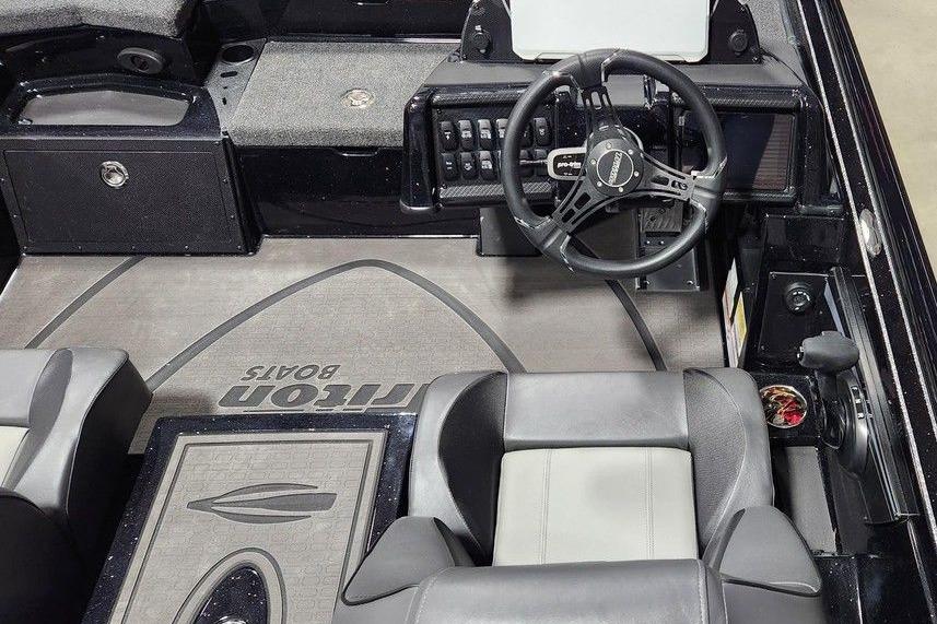 2026 Triton 20XP Patriot boat interior with steering wheel and seating.