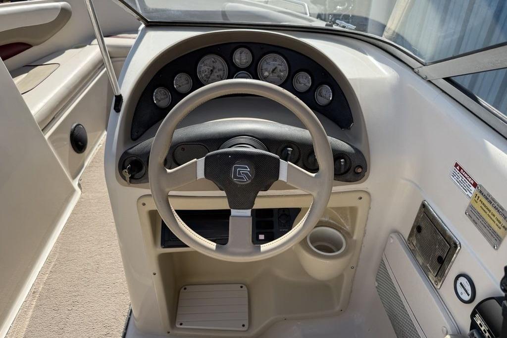 1999 Glastron GT 225 boat dashboard with steering wheel and instrument panel.