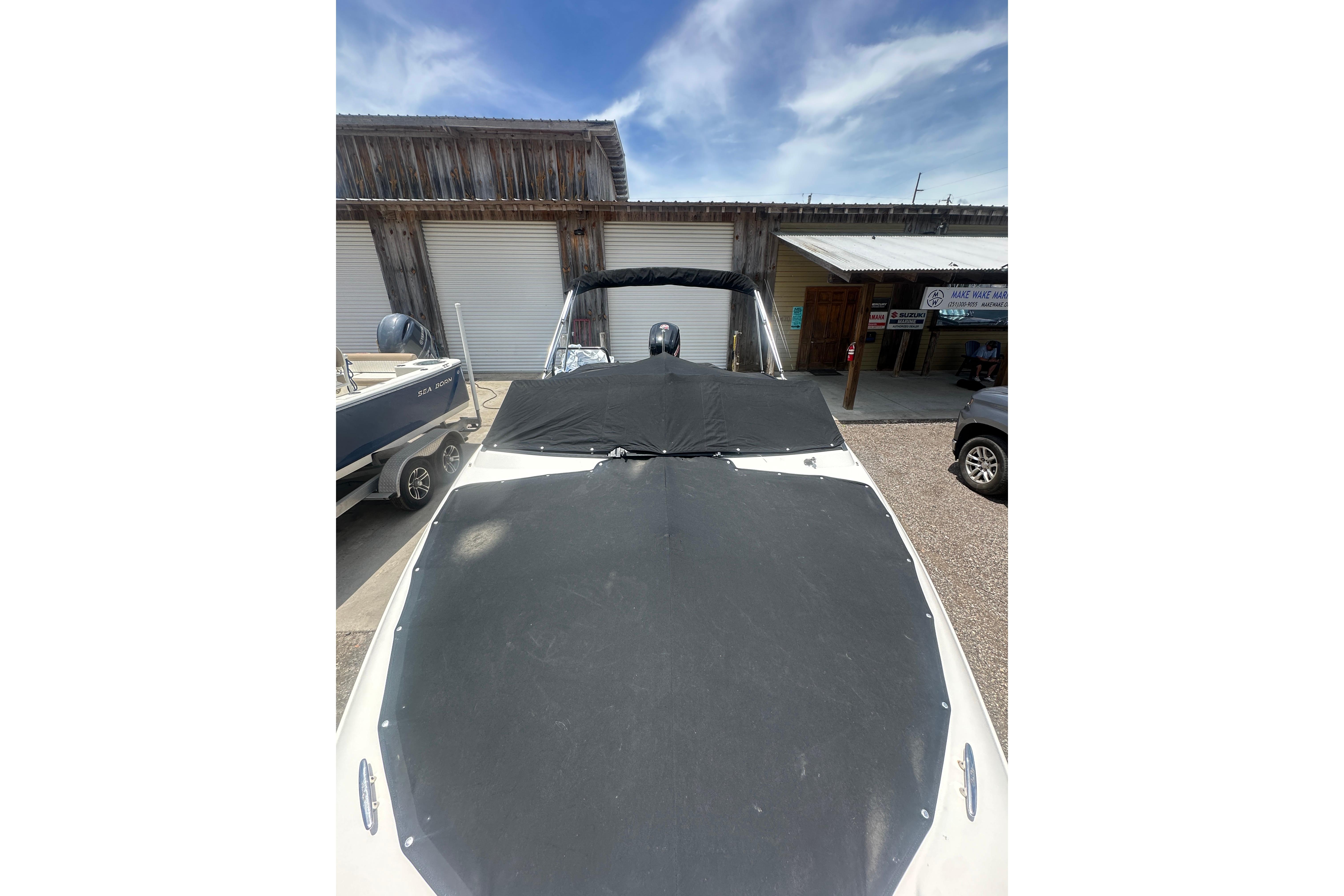 2017 Sea Ray SPX 190 Outboard boat with cover, parked outdoors under a blue sky.