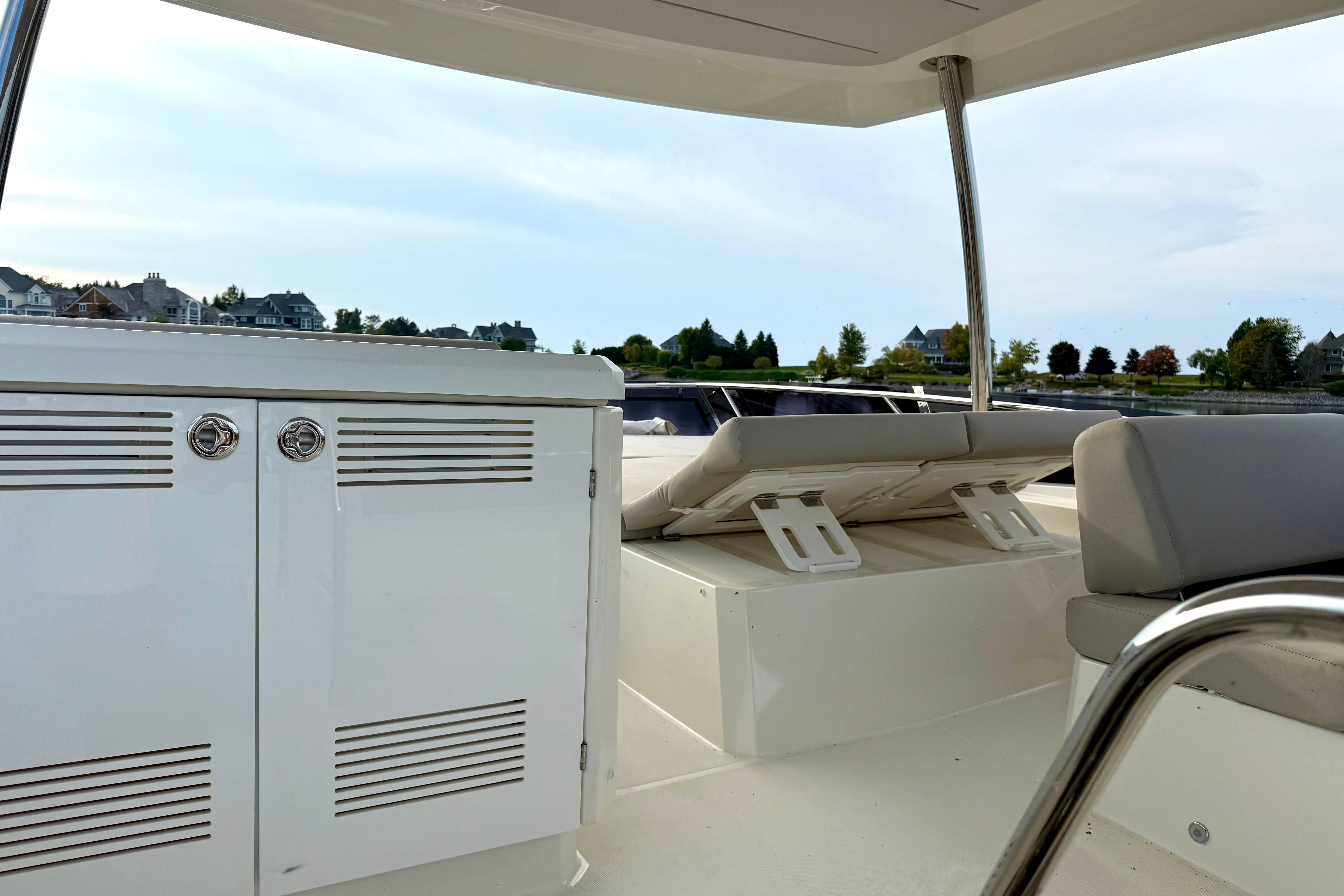 Prestige 590 yacht interior, 2020 model, featuring sleek white cabinetry and comfortable seating.