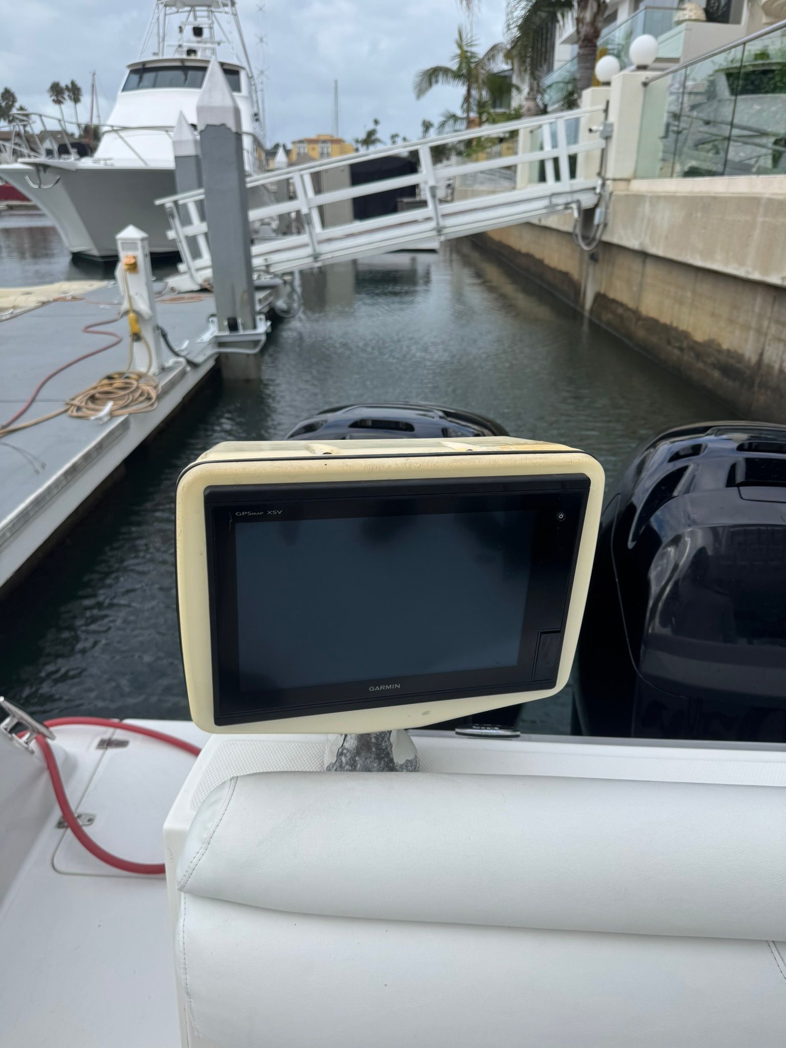 A navigation screen on a boat in a marina, with water and other boats in the background.