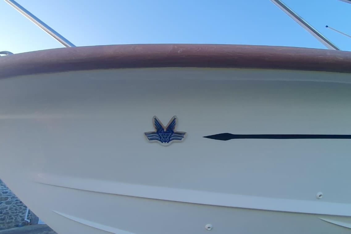 Close-up of 1989 Fairey Spearfish MKIII boat hull with emblem and sleek design.