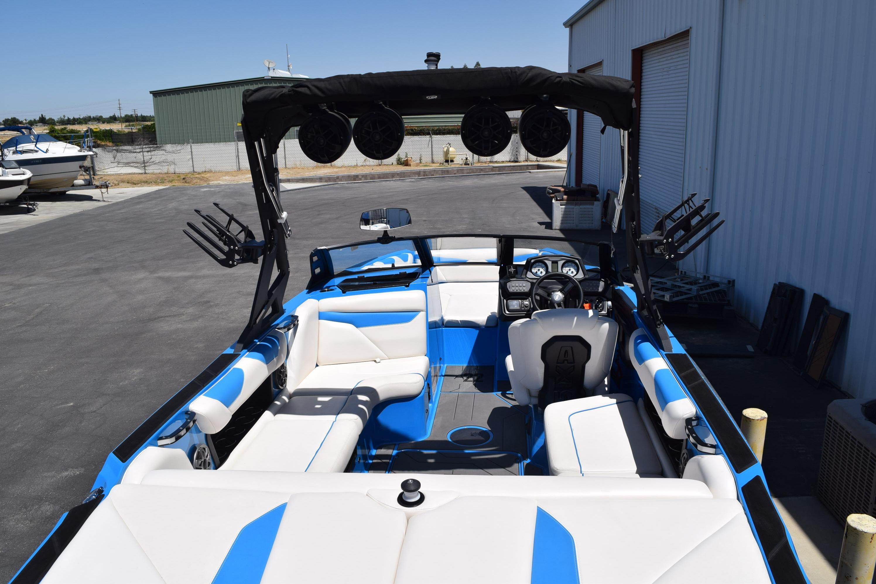 2019 Axis A22 boat with blue and white interior, parked near a warehouse.