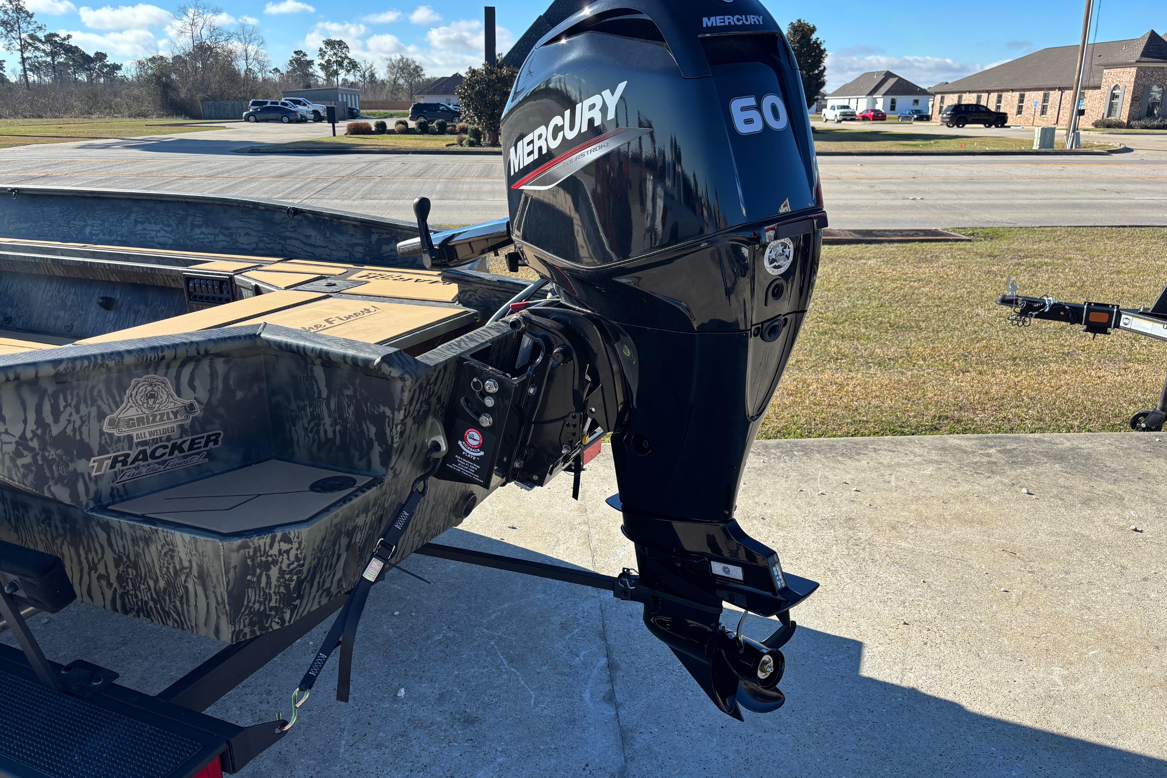2026 Tracker Grizzly 1756 T Marsh boat with Mercury 60 outboard motor in a parking lot.