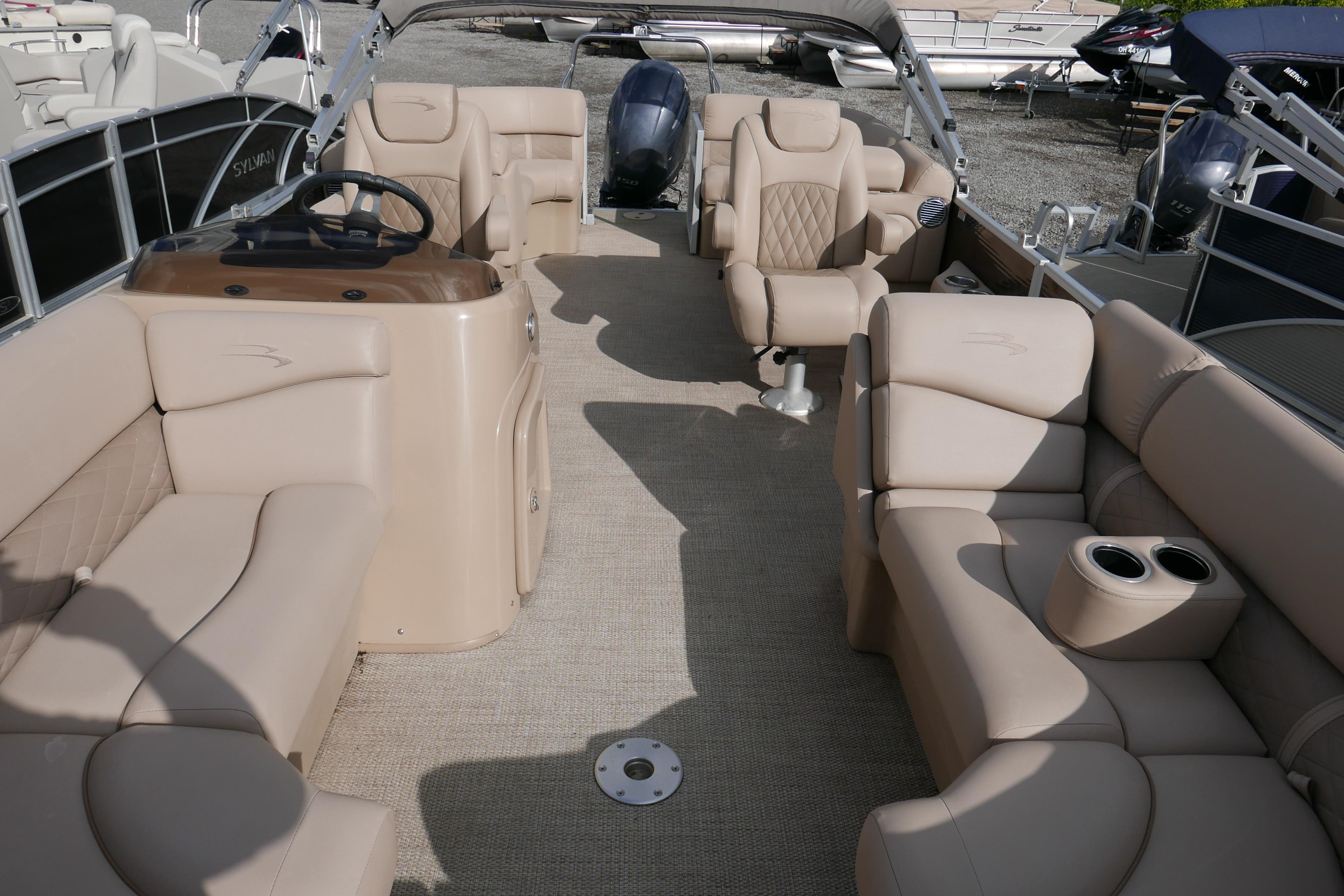 2018 Bennington 22 SSRX pontoon boat interior with beige seating and steering console.