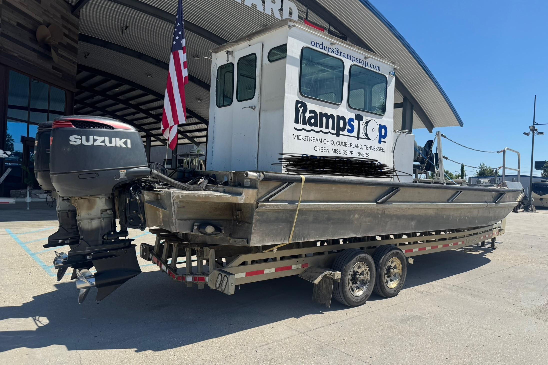 Custom Aluminum Work Boat 33, 2010 model, with Suzuki outboard motor on trailer.