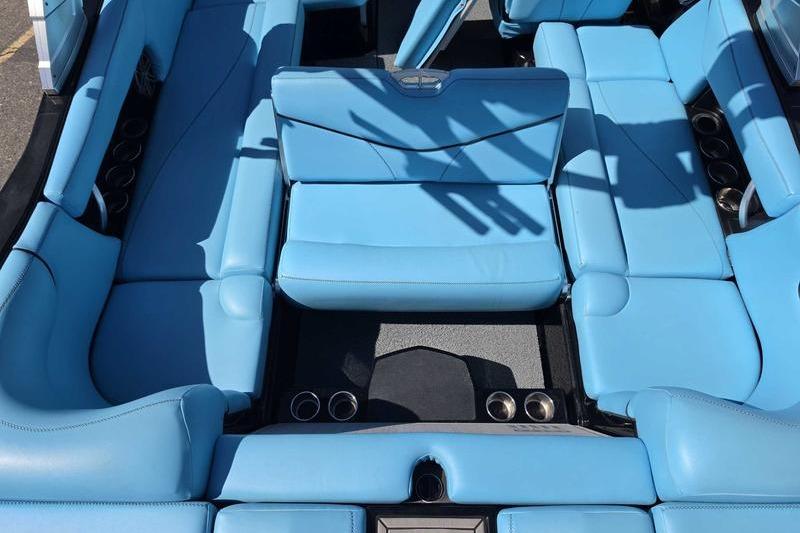 2017 MasterCraft X23 boat interior with blue seating and cup holders.