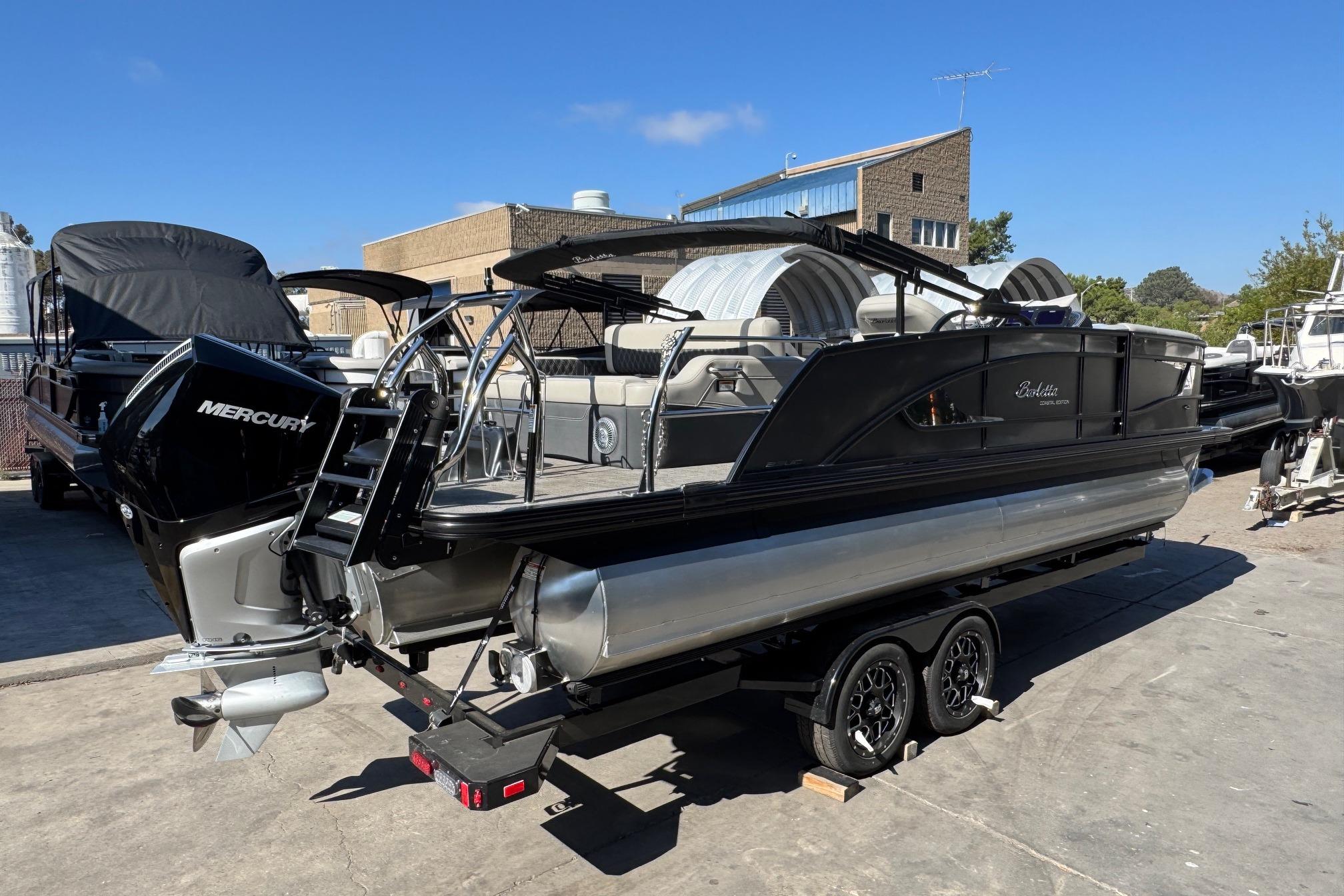 2026 Barletta Lusso 23UC pontoon boat with Mercury engine on trailer.