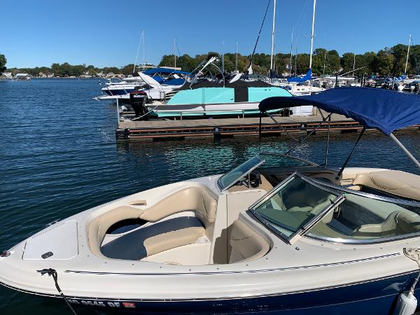 Sea Ray 210 Bow Rider 2000 model docked at a marina on a sunny day.