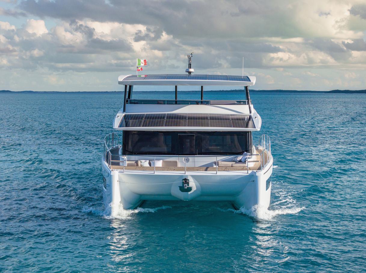 Silent 62 yacht cruising on open sea, 2026 model, with solar panels and flags.