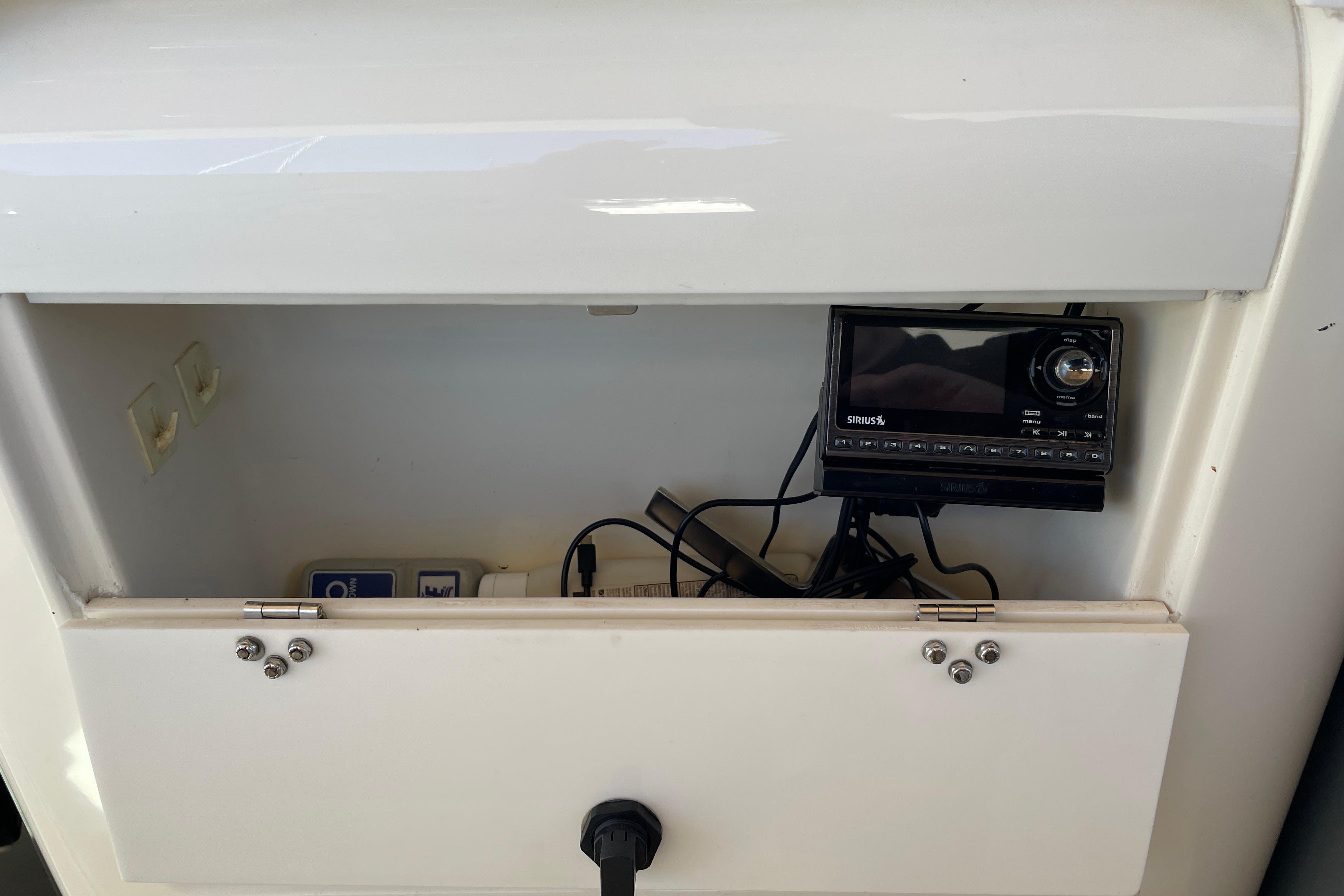 Open storage compartment on 1995 Tiara 3500 EXPRESS with Sirius radio and cables.