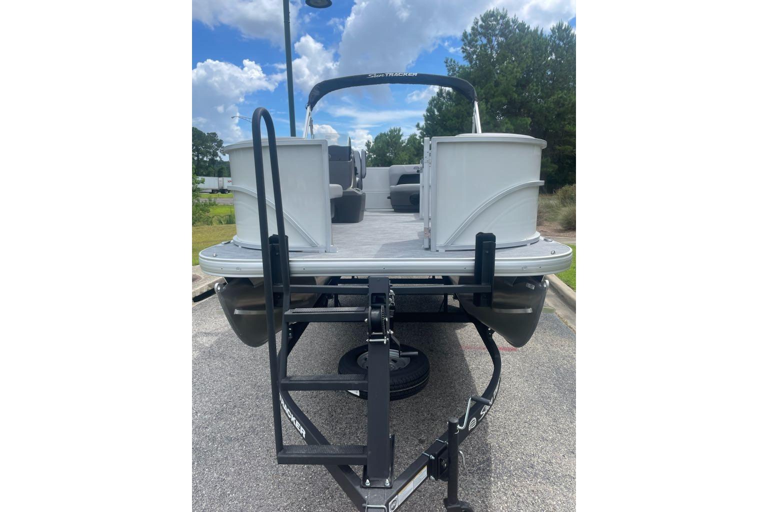 2026 Sun Tracker Party Barge 16 DLX pontoon boat on trailer, parked outdoors.