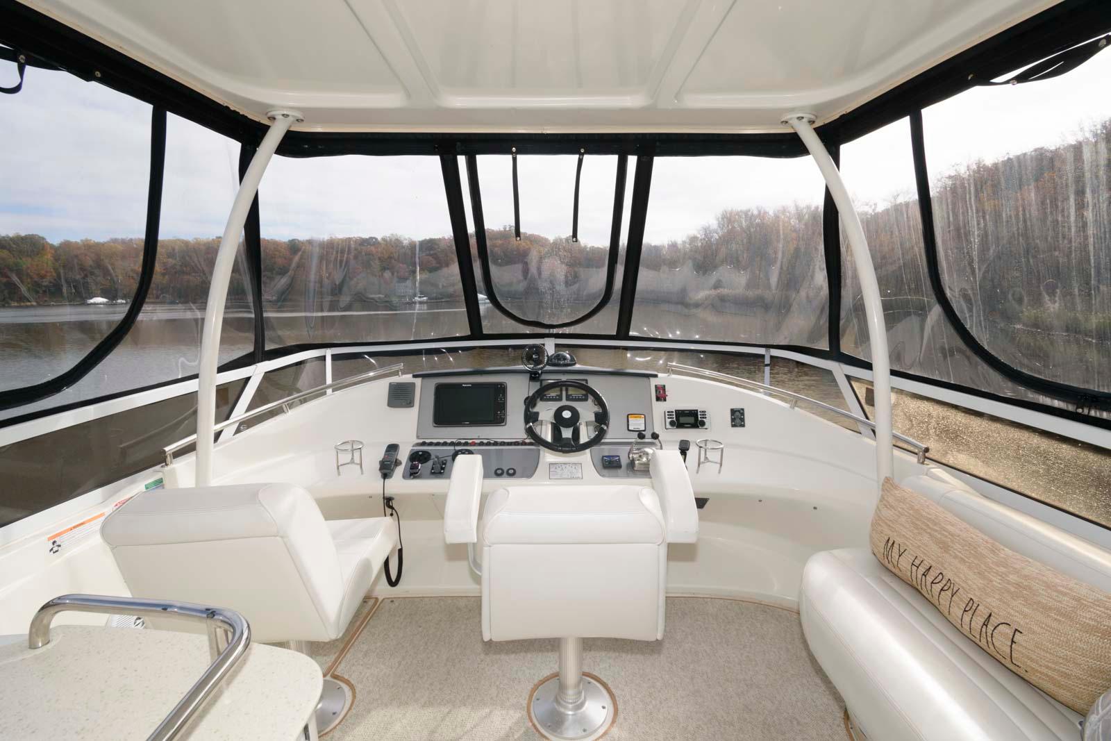 Interior helm of 2007 Carver 43 Motor Yacht with panoramic windows and modern controls.