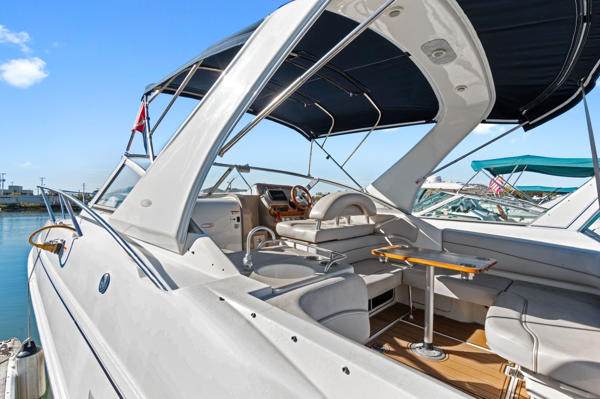 The image shows a 2007 Larson Cabrio 330 with an open cockpit and seating area at the dock.