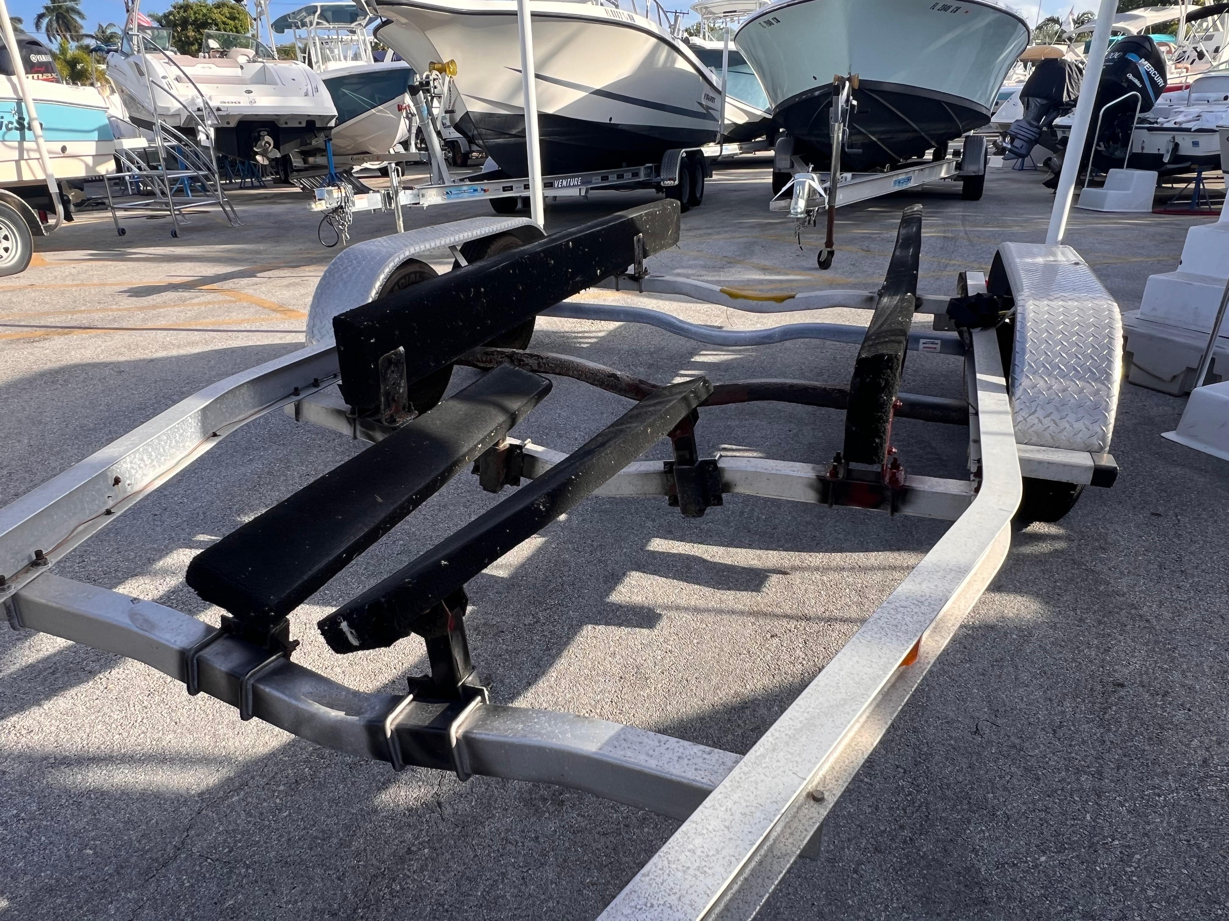 2018 Nextrail 19-21 Tandem Axel trailer in a boatyard, surrounded by boats.