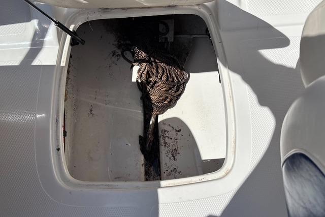 Open storage compartment in 2012 Tahoe Q8 SSi boat with coiled rope inside.