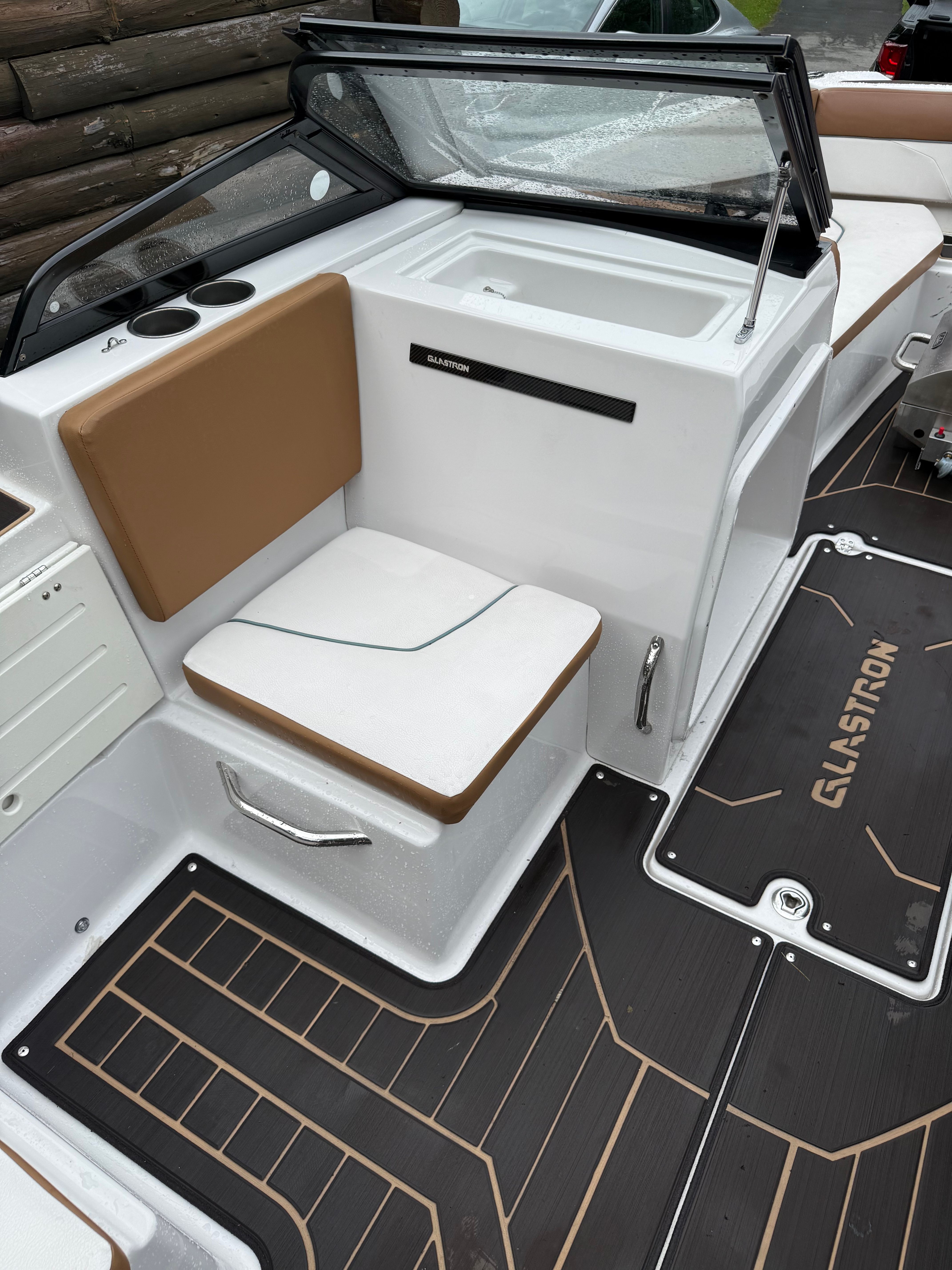 The image shows the cockpit of a 2019 Glastron GTDW 225 with white and brown seating.