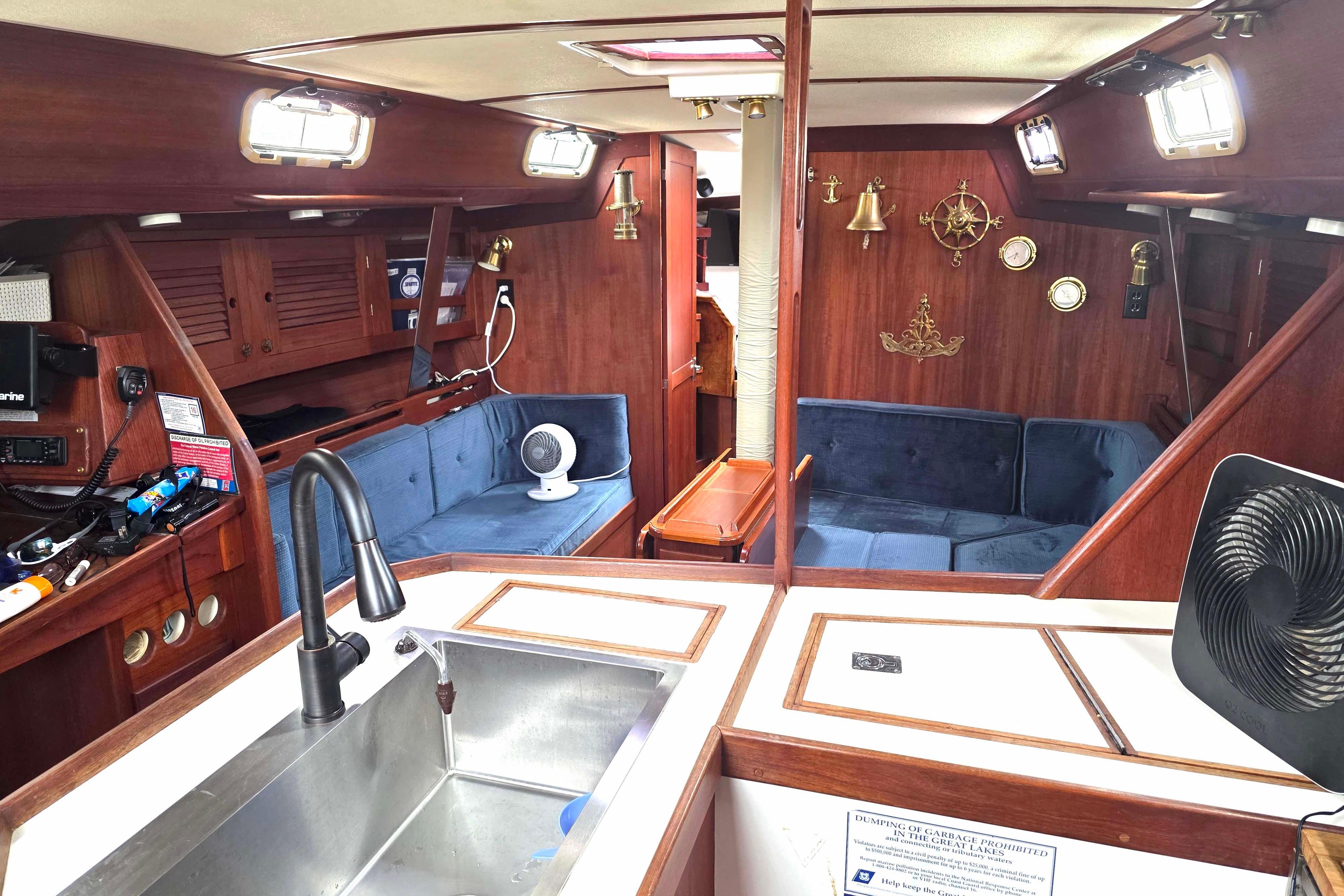 Interior of a 1990 Tartan 372 sailboat with wood finish and blue seating.