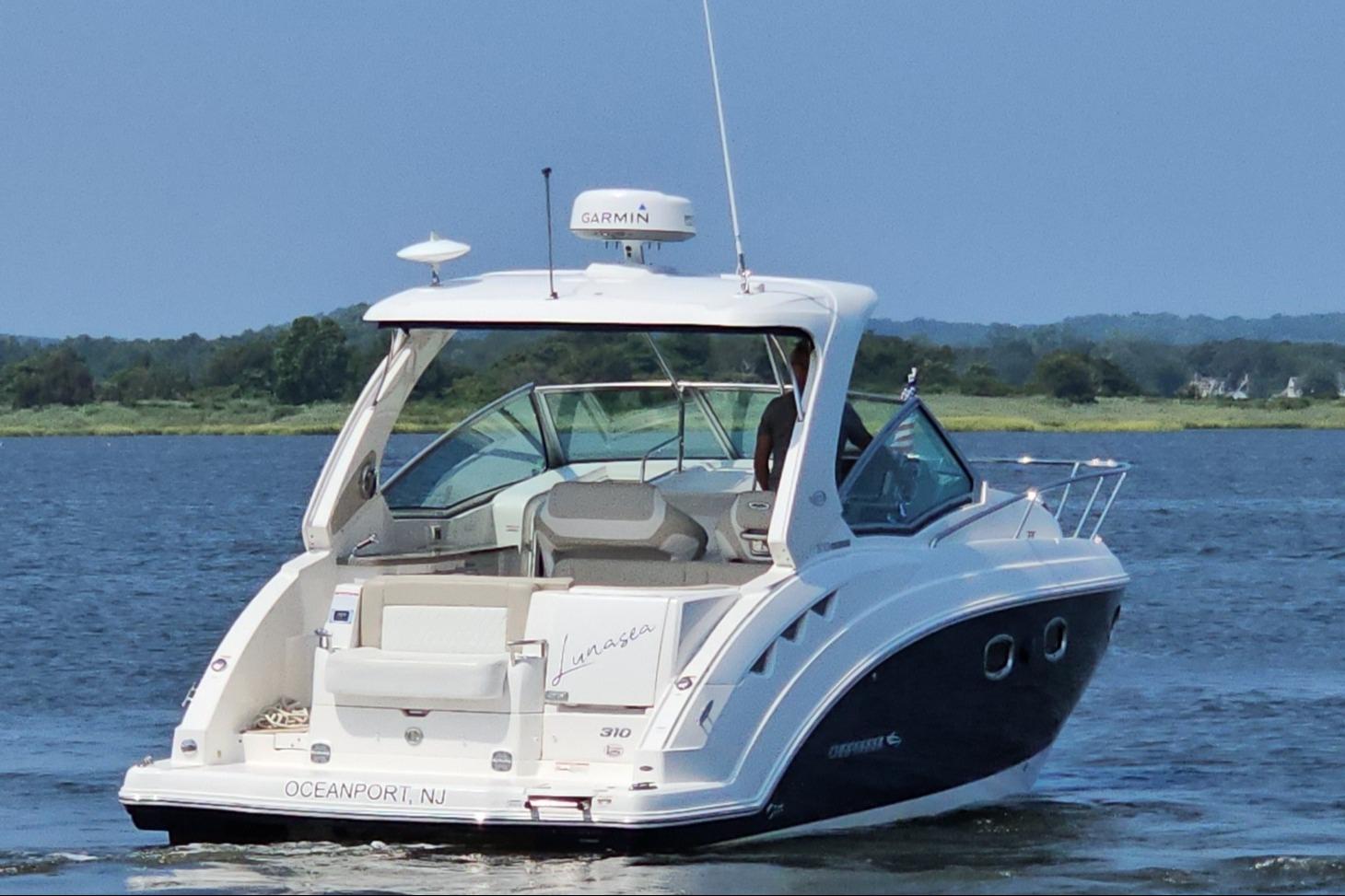 2015 Chaparral 310 Signature boat cruising on a serene lake.