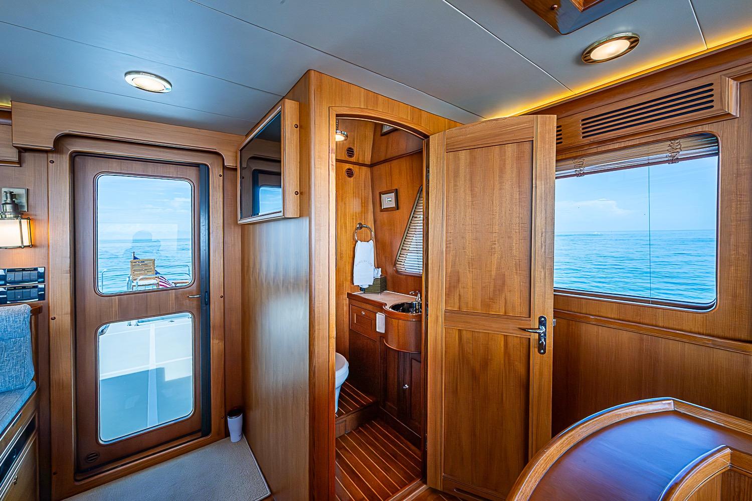 Luxurious 2014 Marlow 80 Explorer yacht interior with wooden finishes and ocean view.