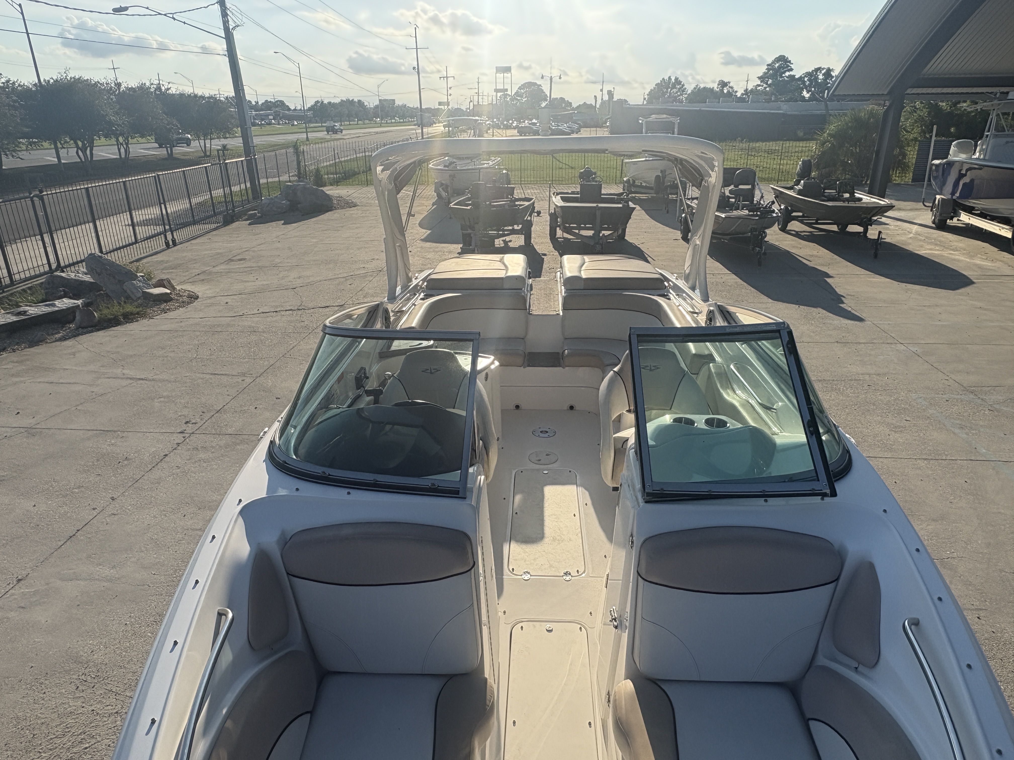 2013 Rinker Captiva 276 boat with open seating, parked outdoors on a sunny day.
