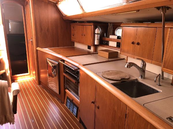 Interior of 2001 Jeanneau 45.2 yacht with wooden cabinetry and modern kitchen amenities.