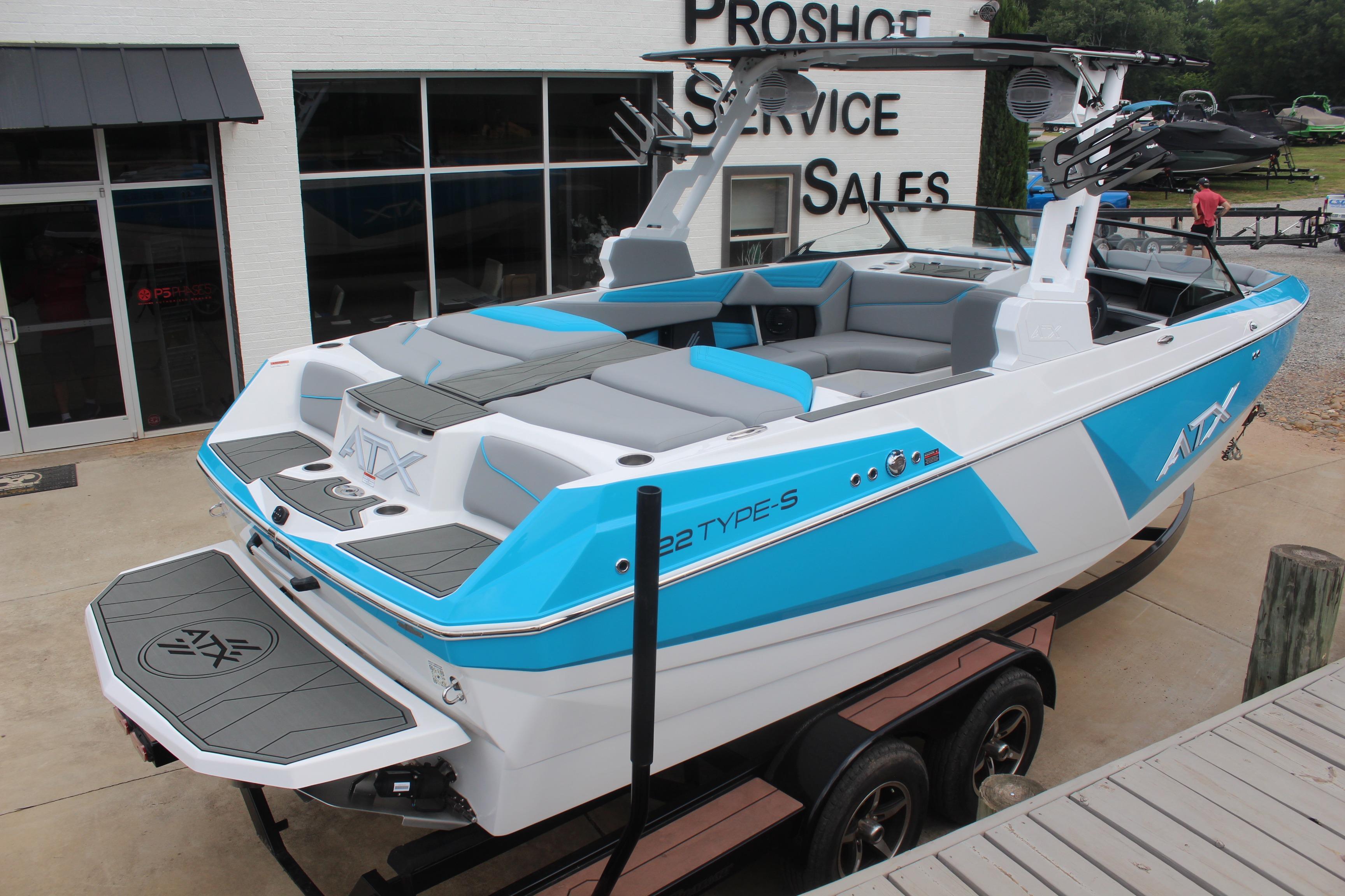 2026 ATX Surf Boats 22 Type-S in blue and white, displayed at a dealership.