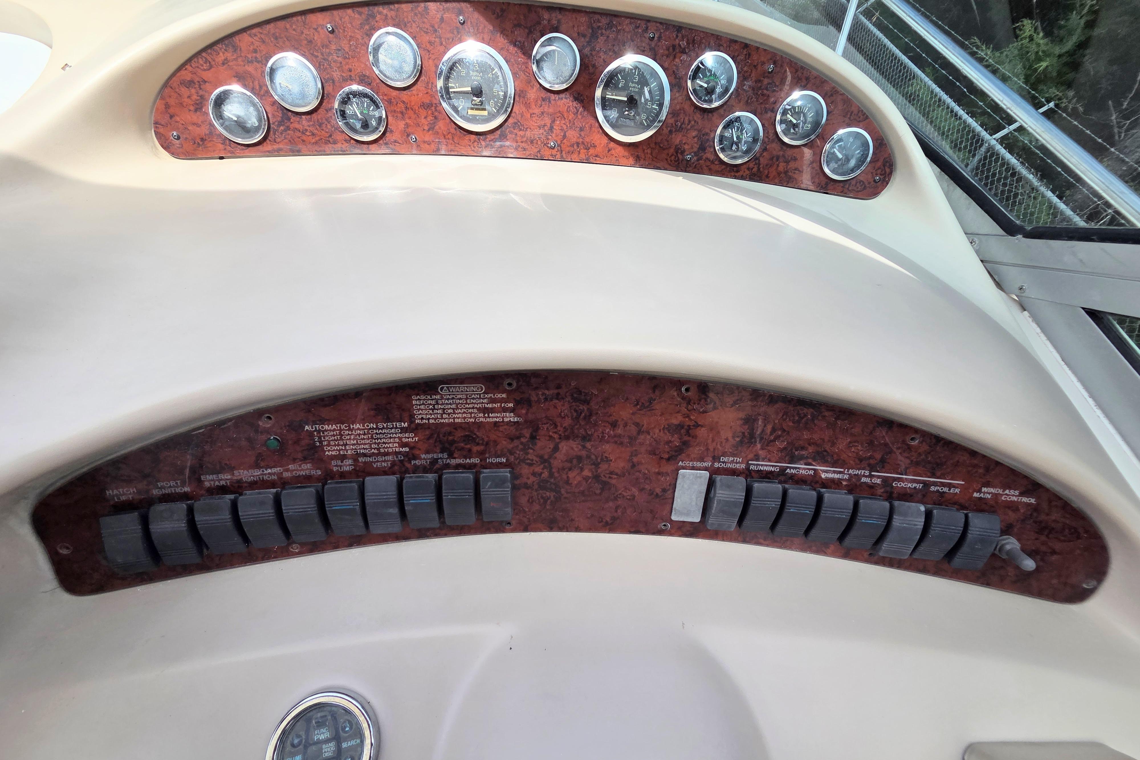 Dashboard of a 2000 Sea Ray 340 Sundancer boat with gauges and switches.