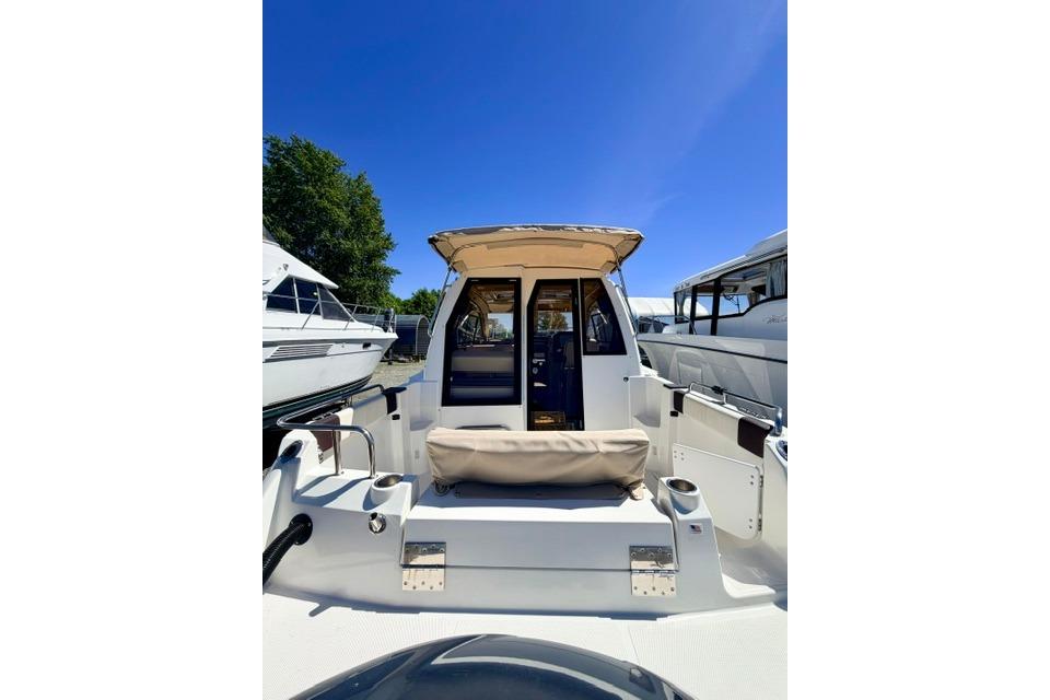 2017 Cutwater C-242 Coupe boat with seating, docked under clear blue sky.