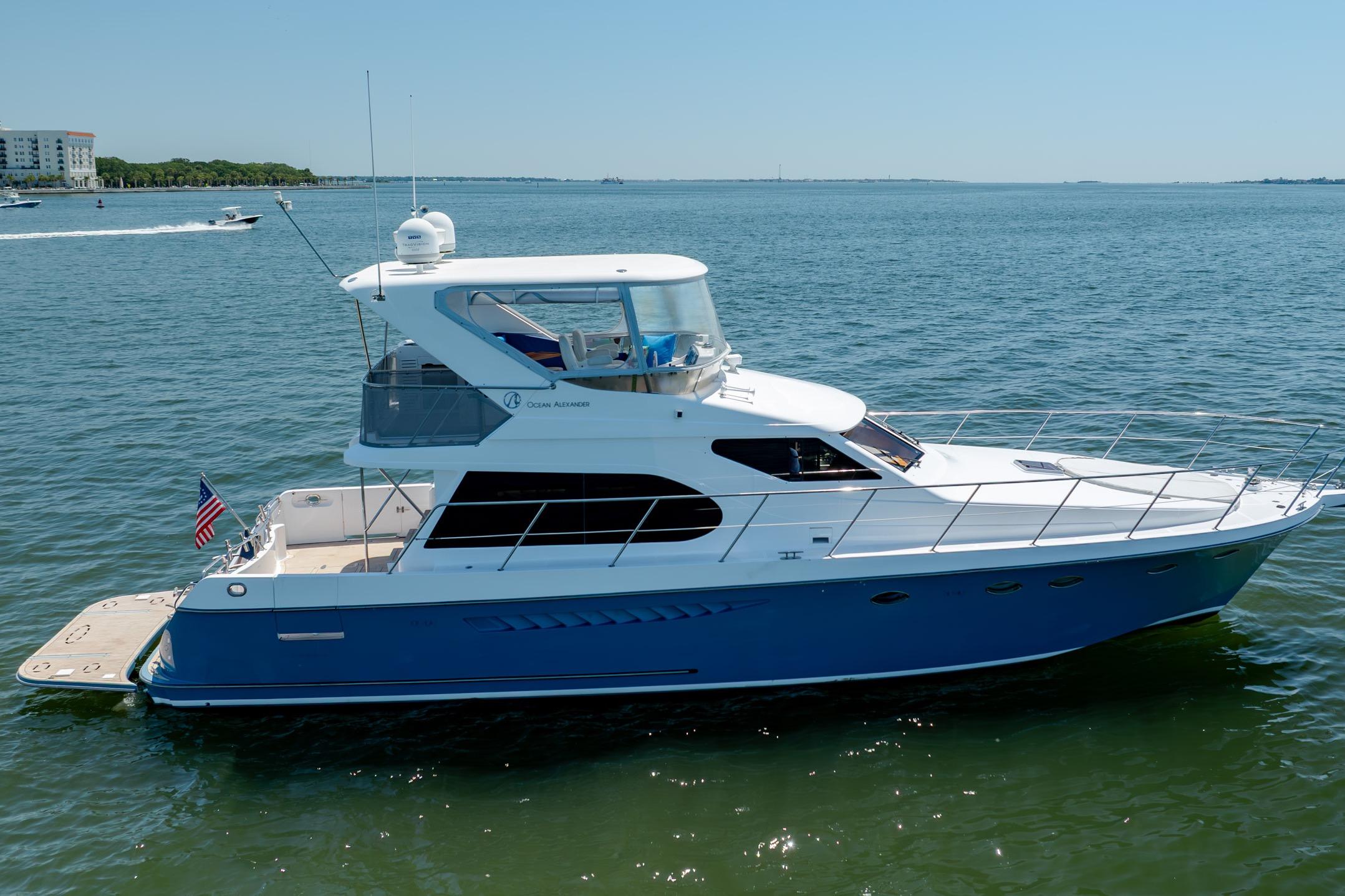 Ocean Alexander yacht cruising on calm waters under clear blue skies.