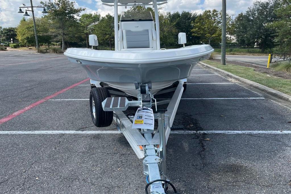 2026 Mako 24 APEX boat on trailer in parking lot.