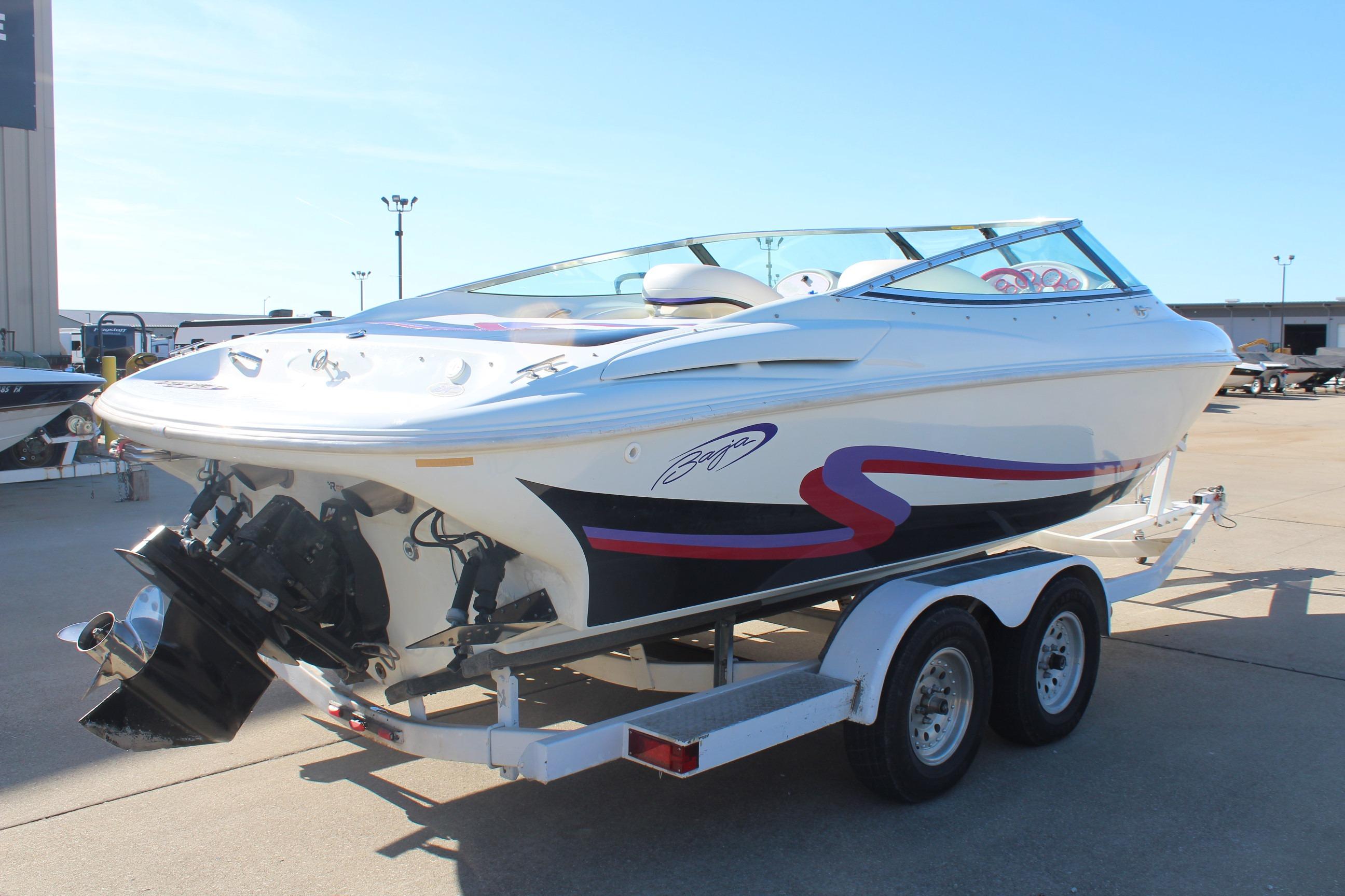 1996 Baja 232 speedboat on trailer, white with red and black accents, parked outdoors.