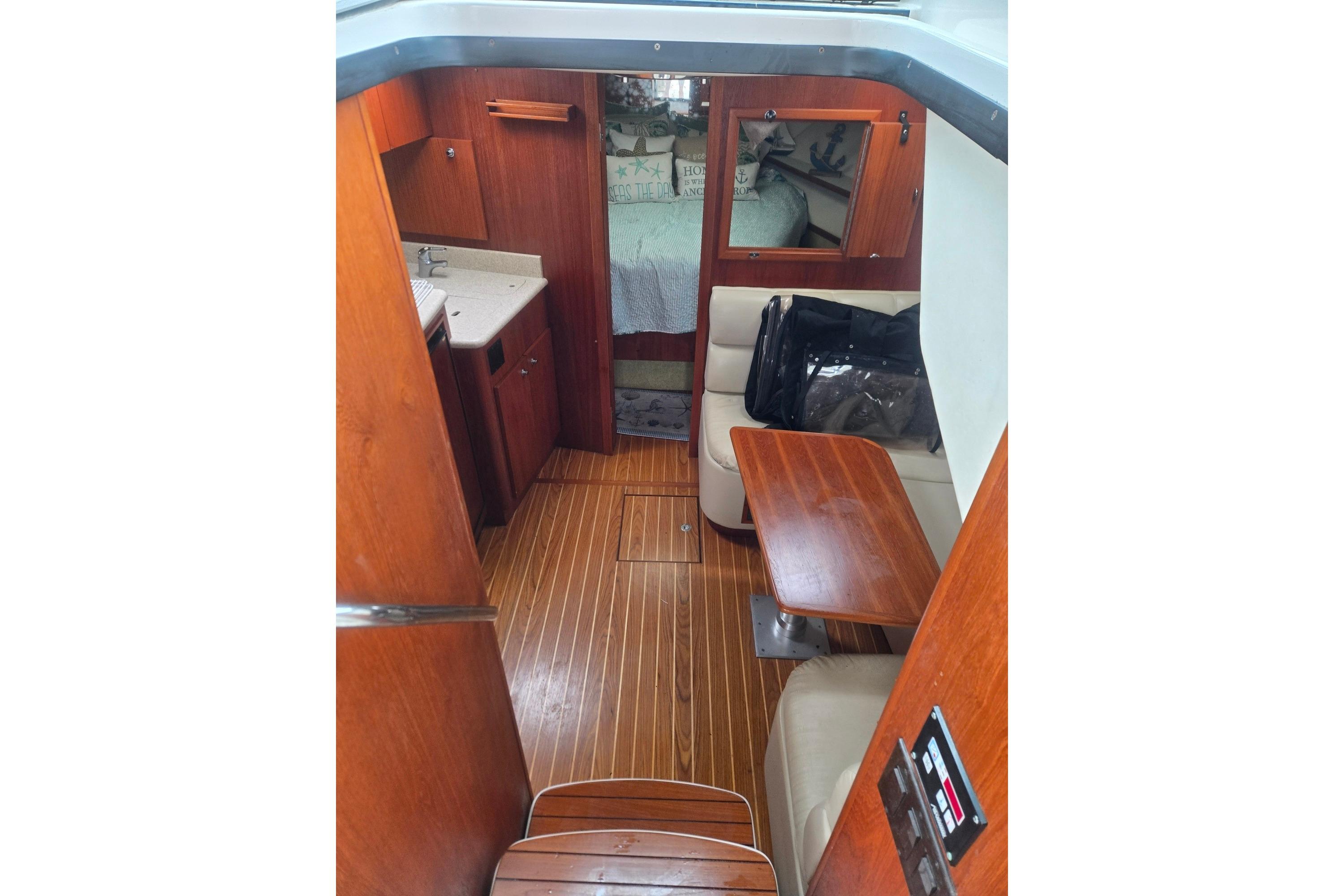 Interior of 2002 Tiara Yachts 3500 Open with wood finish and seating area.